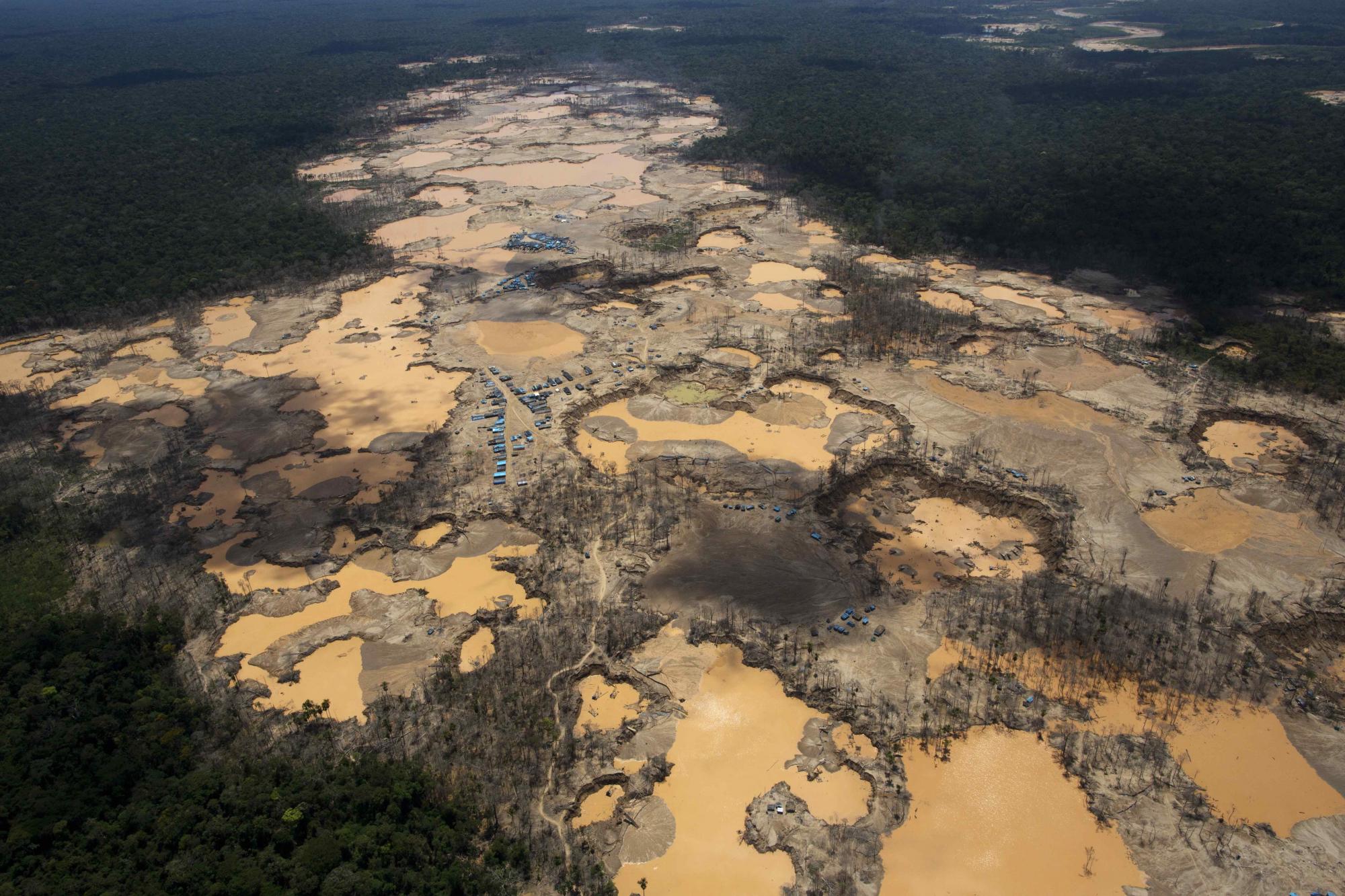 En esta imagen de archivo del 11 de noviembre de 2014, una imagen muestra una zona deforestada salpicada de carpas azules, que identifican los asentamientos de mineros, y cráteres llenos de agua provocados por la minería ilegal de oro en La Pampa, en la región peruana de Madre de Dios. El gobierno de Perú declaró la emergencia en la amplia zona selvática por la contaminación de mercurio, en gran parte causada por la minería clandestina de oro. Un decreto de 60 días emitido el 23 de mayo de 2016 afectó a 11 distritos de la zona, donde se han detectado altos niveles de esta sustancia tóxica en la gente, los ríos y el pescado.