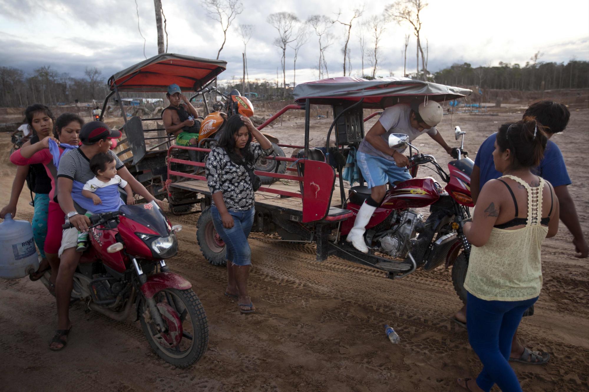 En esta imagen de archivo del 16 de mayo de 2014, varios mineros abandonan el lugar donde vivían y trabajaban después de que la policía destruyera su explotación de minería ilegal en La Pampa, en la región peruana de Madre de Dios, el viernes 16 de mayo de 2014. El estado de Madre de Dios tiene unos 40.000 mineros ilegales, la mayoría migrantes pobres de las tierras altas andinas.