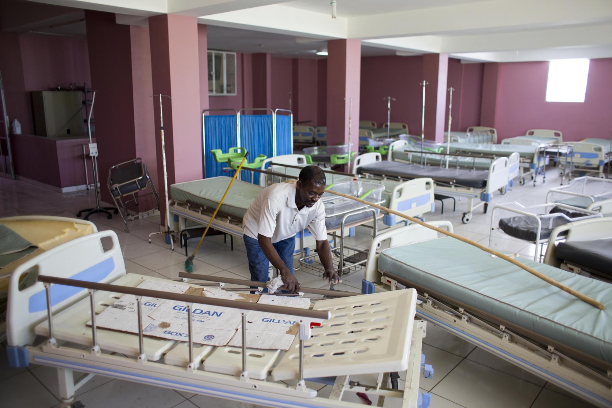 En esta imagen del 15 de julio de 2016, un trabajador mueve una camilla mientras barre el ala vacía patología en el hospital de La Paix en Delmas, Haití. Médicos y estudiantes en prácticas paralizaron sus labores en marzo.