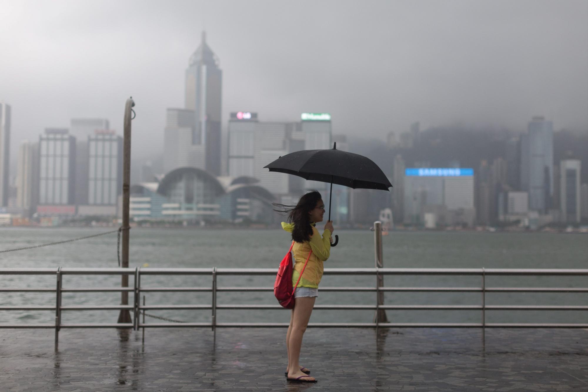  Una mujer observa desde el puerto Victoria afectado por los fuertes vientos del tifón Nida.