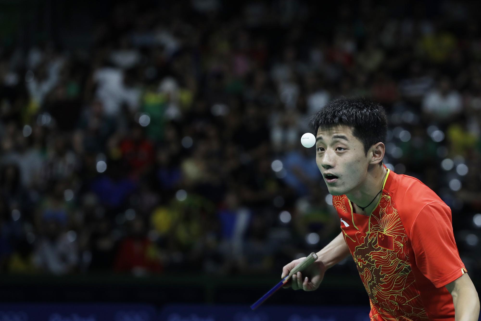 Zhang Jike de China observa la pelota mientras juega contra Koki Niwa de Japón durante su partido de cuartos de final de tenis de mesa.