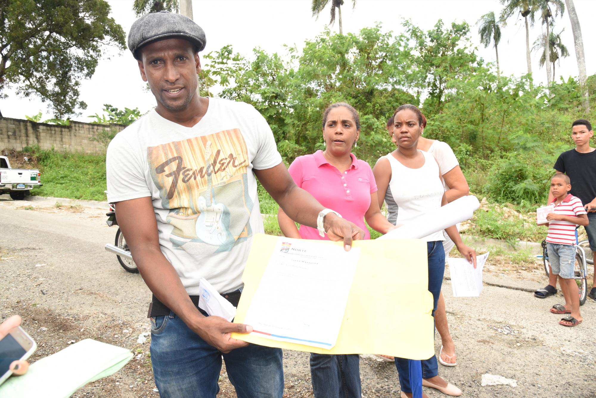 Propietario y residente de los apartamentos Doña Elba II, Santos Solano, muestra un documento del Ayuntamiento de Santo Domingo Norte que ordena que no se construya un muro