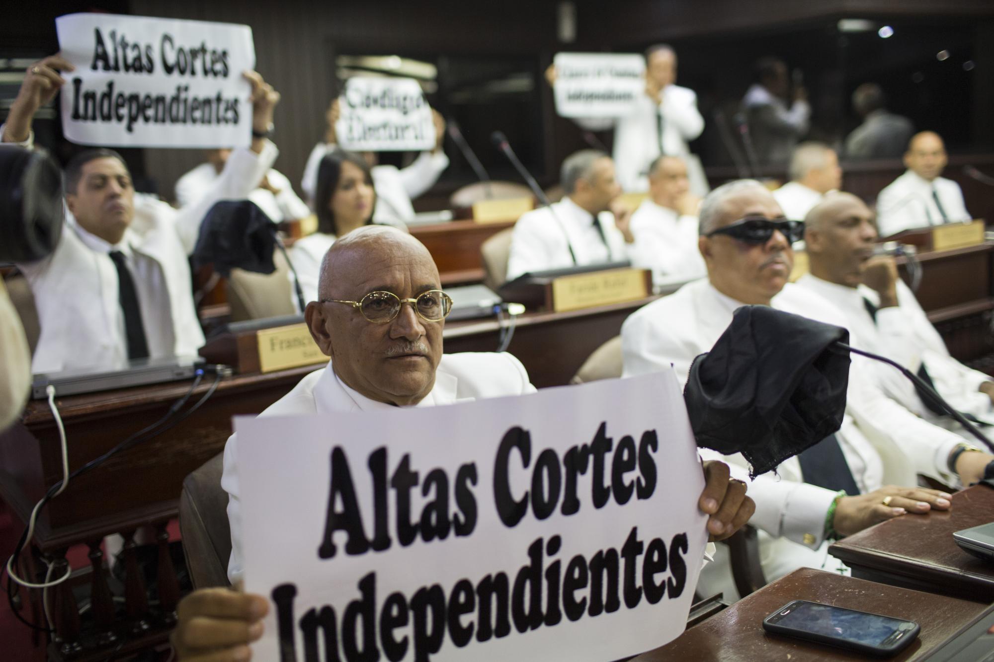 Diputados del Partido Revolucionario Moderno protestaron con pancartas durante la juramentación de Lucía Medina, hermana del presidente de la República, como presidenta de la Cámara de Diputados, el 16 de agosto de 2016.