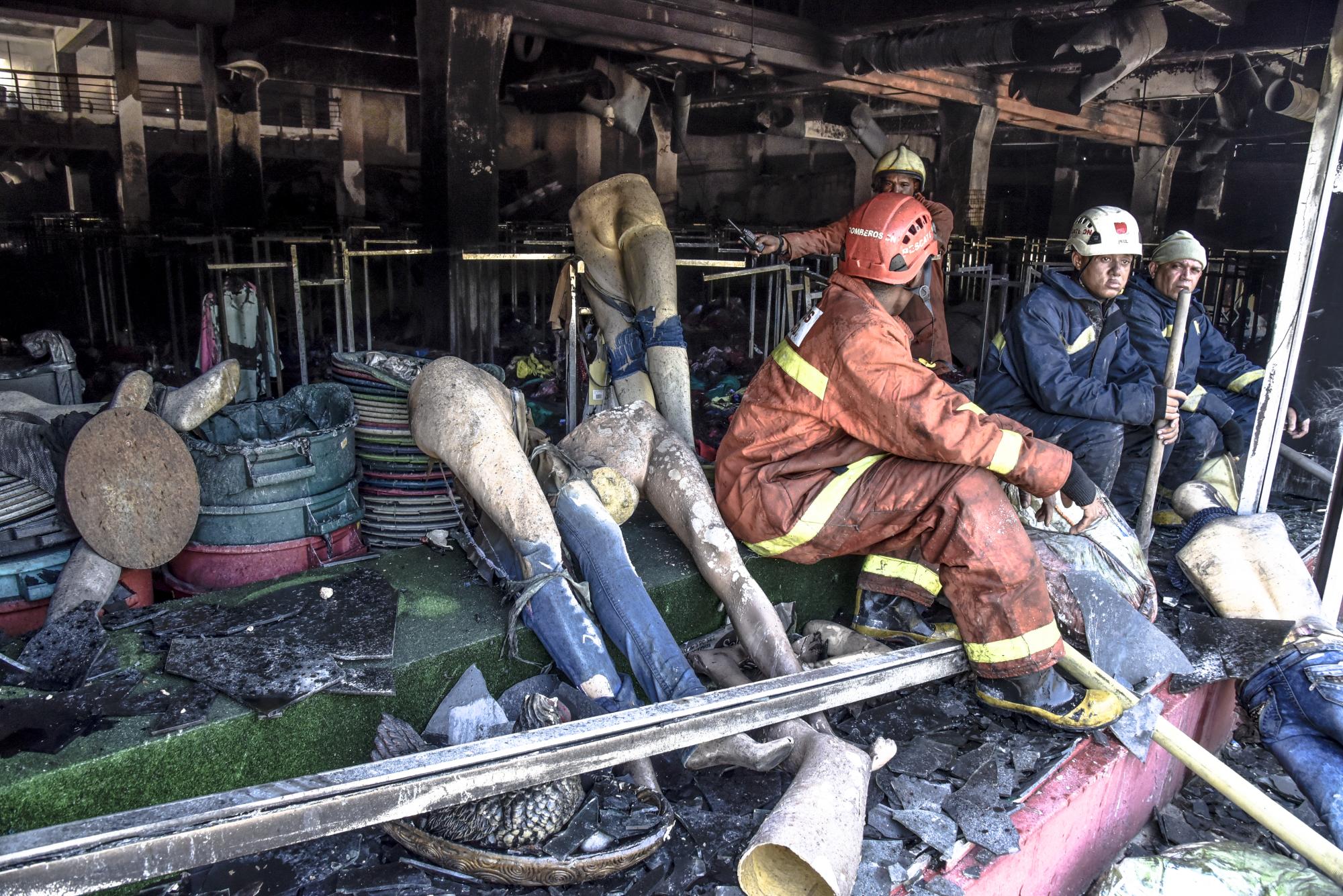 Miembros del Cuerpo de Bomberos trabajan el viernes 19 de agosto en las labores de extinción del incendio que afectó el local de la tienda Almacenes Rodríguez, que inició el jueves a las 3:00 pm.