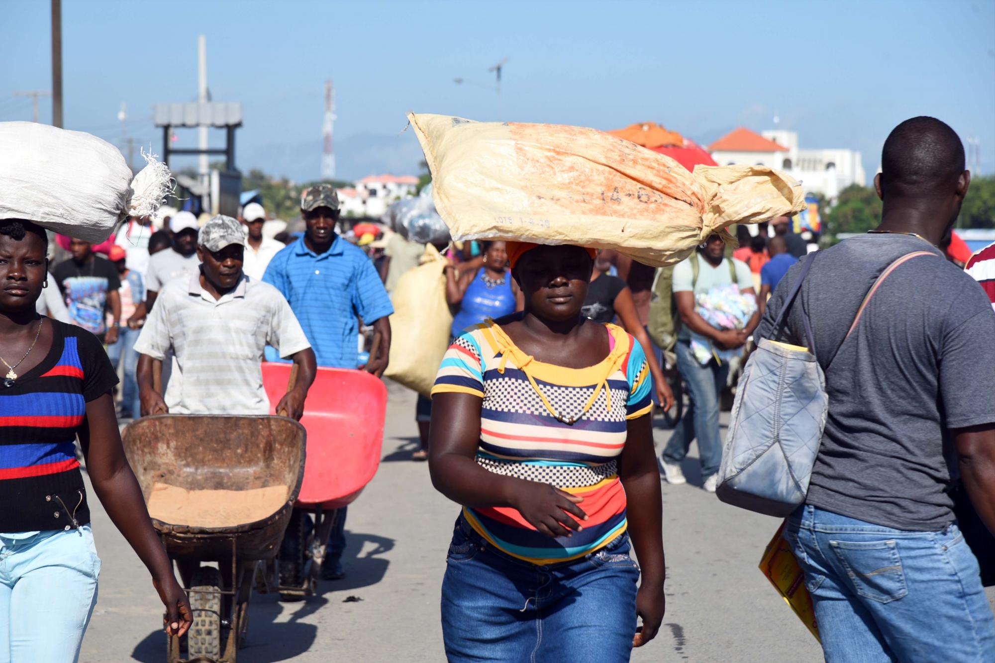 Ciudadanos haitianos cargan mercancías en la frontera.
