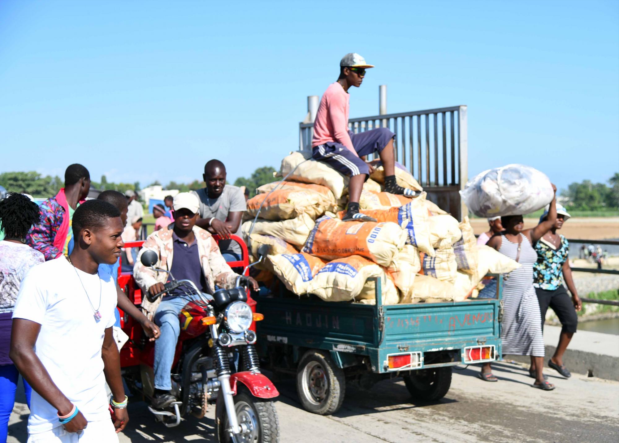 Haitianos cargan mercancías hacia el vecino país. 