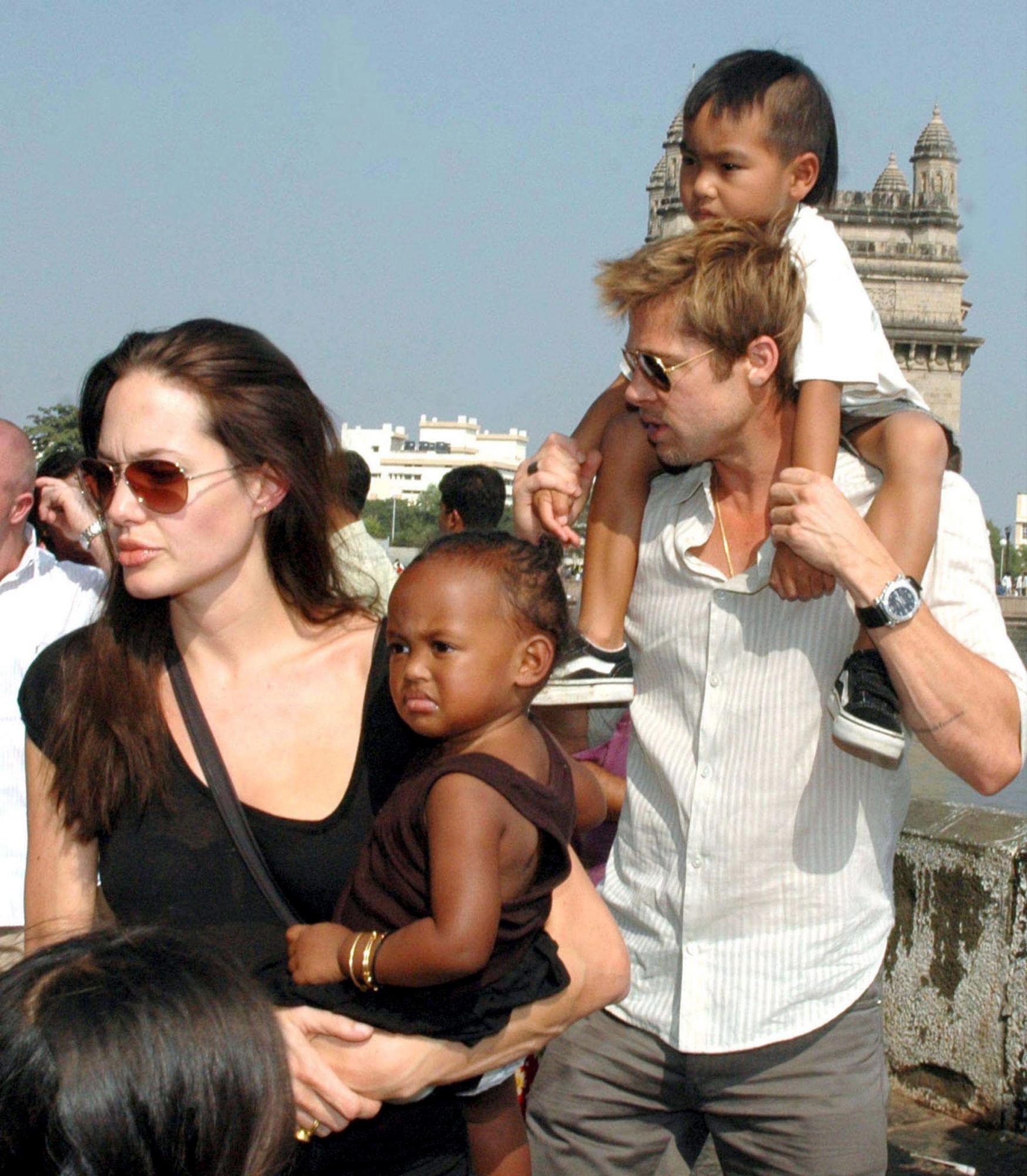 Angelina Jolie (i) con su hija Zahara, y , Brad Pitt (d) junto a su hijo Maddox, paseando en la Puerta de la India en Bombay, India. 