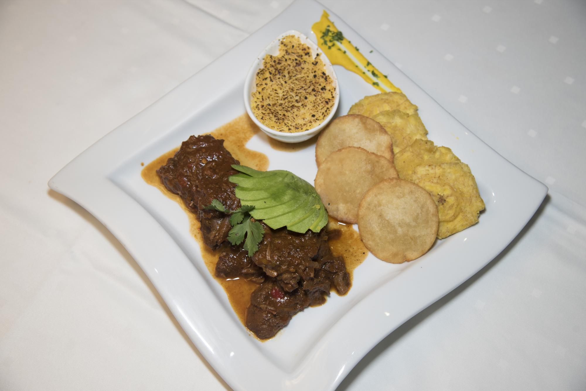 Chivo liniero. Chivo al estilo de la linea: guisado tradicional y flanqueado por chenchén, catibias y tostones.