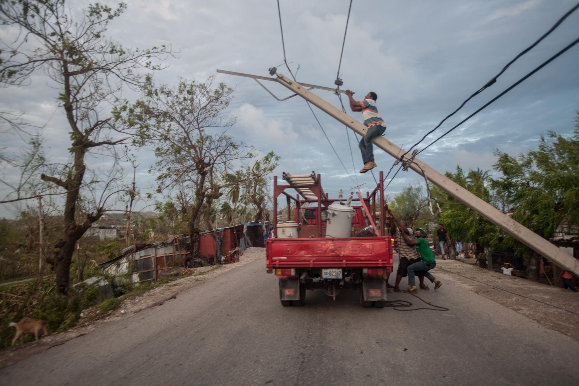 Un hombre intenta arreglar un poste de energía en la ciudad de Kavayon en el suroeste de Haití, después del paso del huracán Matthew por la isla. 