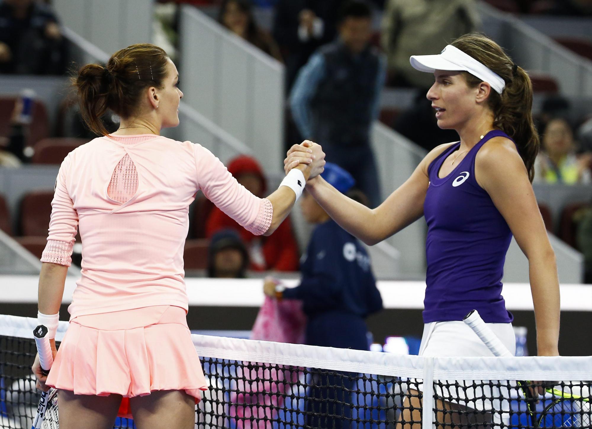 Agnieszka Radwanska (izq) y  Johanna Konta se saludan al  al final del partido por el primer lugar en el Abierto de China.