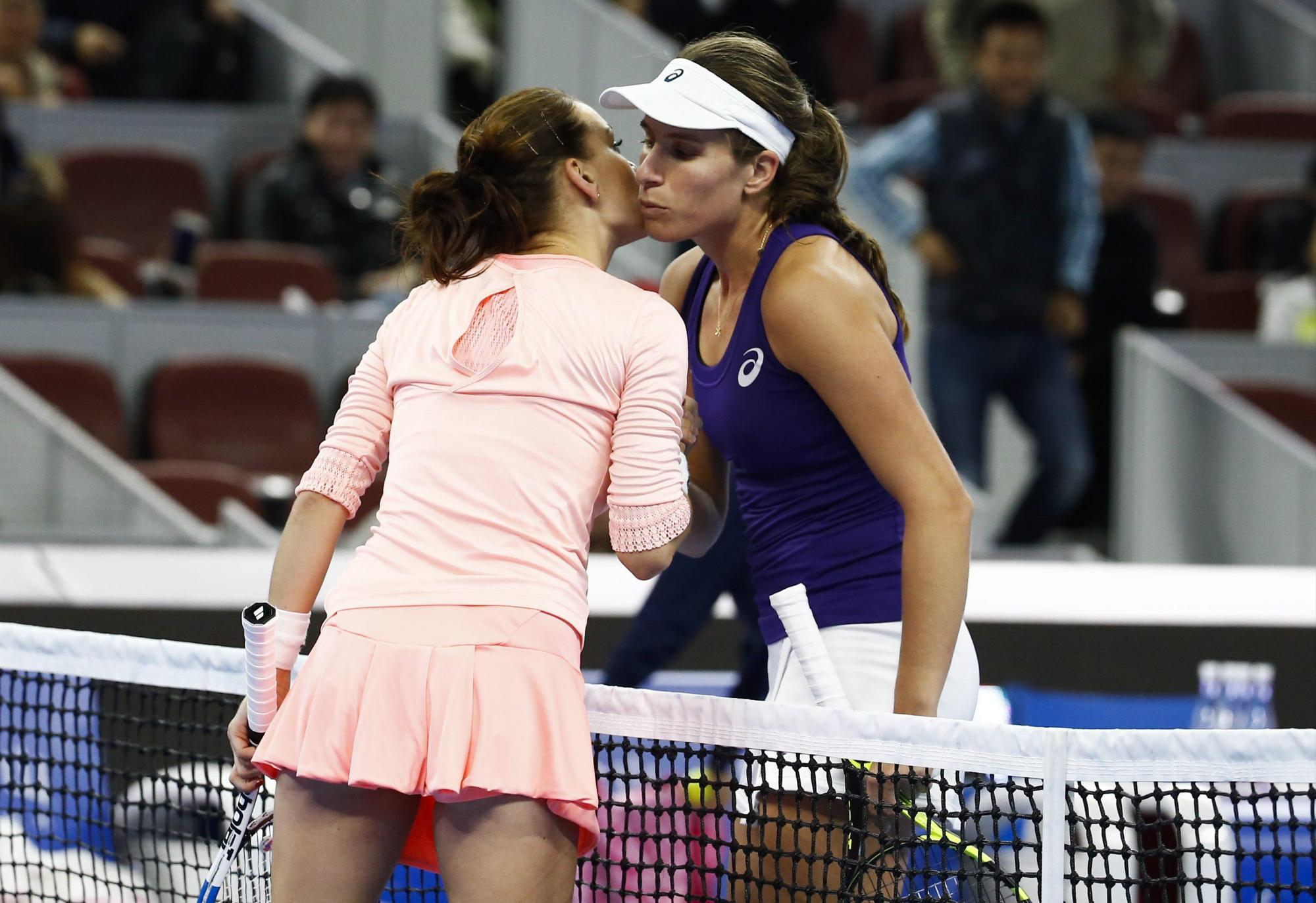 Agnieszka Radwanska (izq) y  Johanna Konta se saludan al  al final del partido por el primer lugar en el Abierto de China.