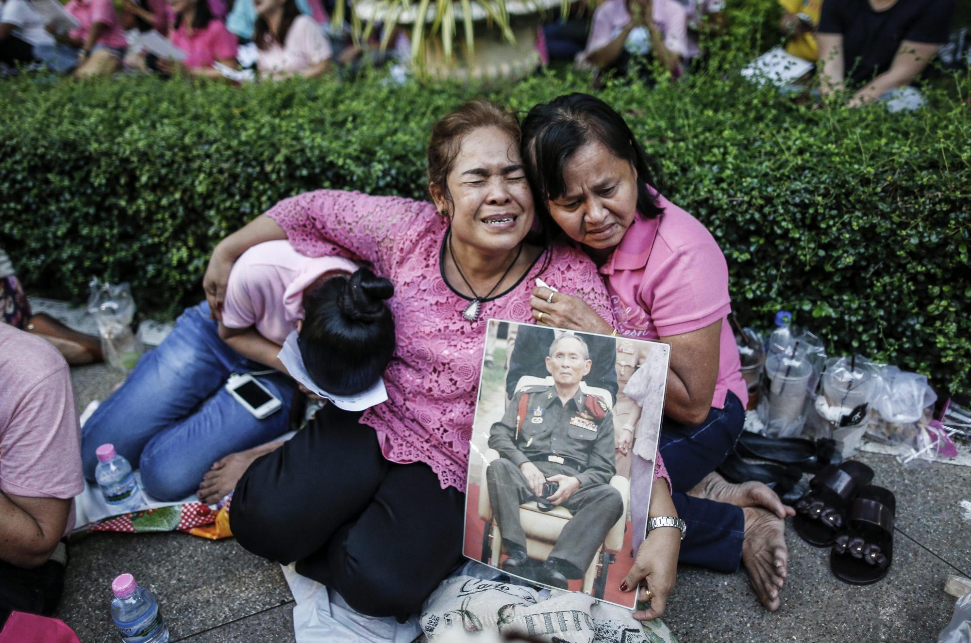 Mujeres tailandesas lloran tras conocer el fallecimiento del rey Bhumibol Adulyadej frente al hospital Siriraj. 