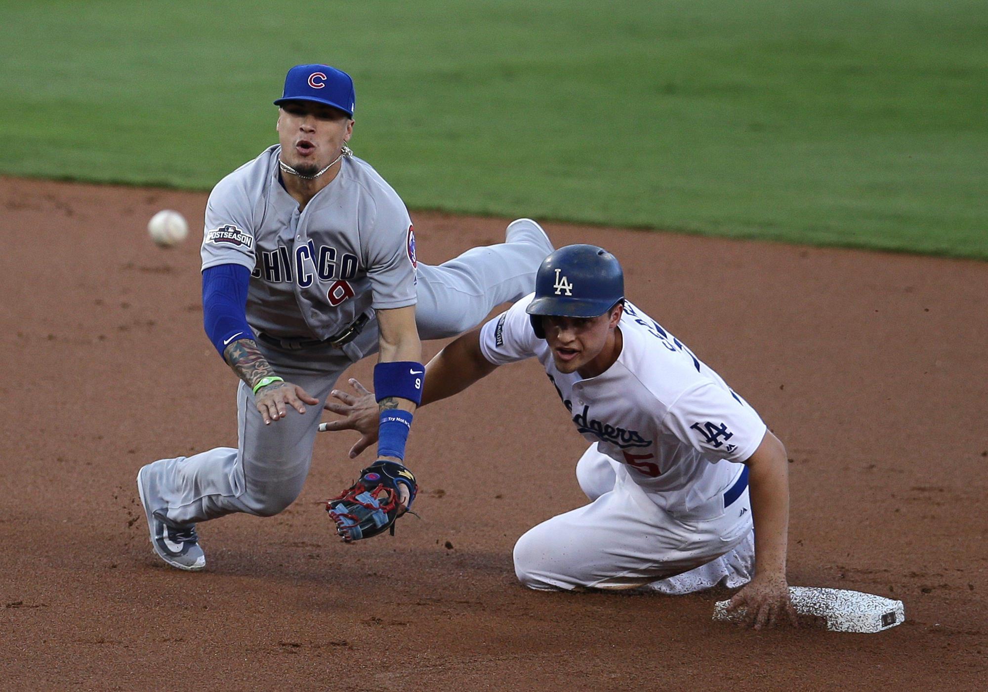 Corey Seager (d) de Dodgers hoy intenta llegar a la intermedia y Javier Báez pretende el out el 19 de octubre de 2016, durante un juego de la Liga Nacional de la MLB en el estadio Dodger de Los Ángeles.