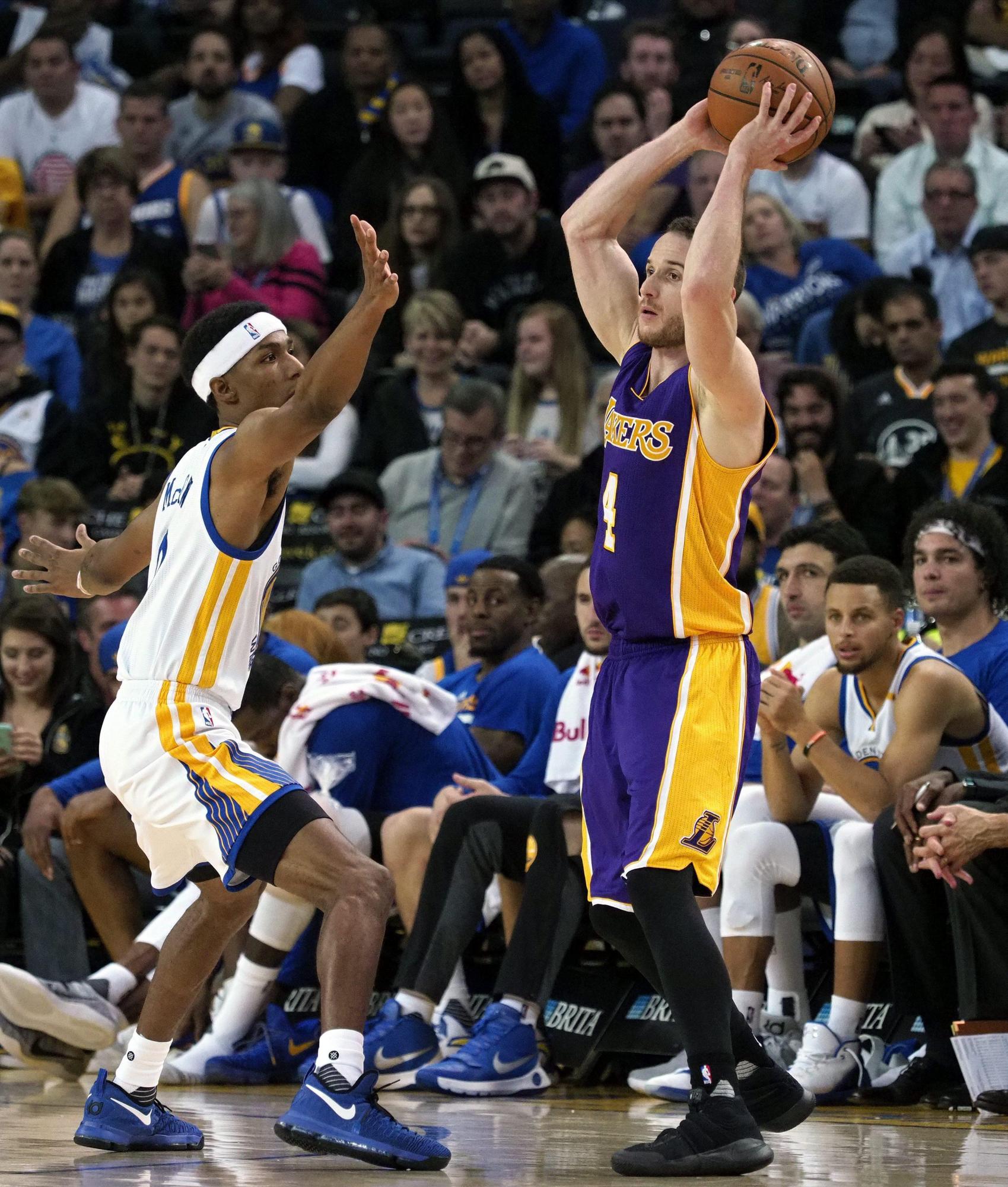 El jugador de los Warriors Patrick McCaw (i) lucha por el balón con el brasileño Marcelo Huertas de los Lakers durante el partido de la NBA que enfrentó a los Warriors y Los Lakers.