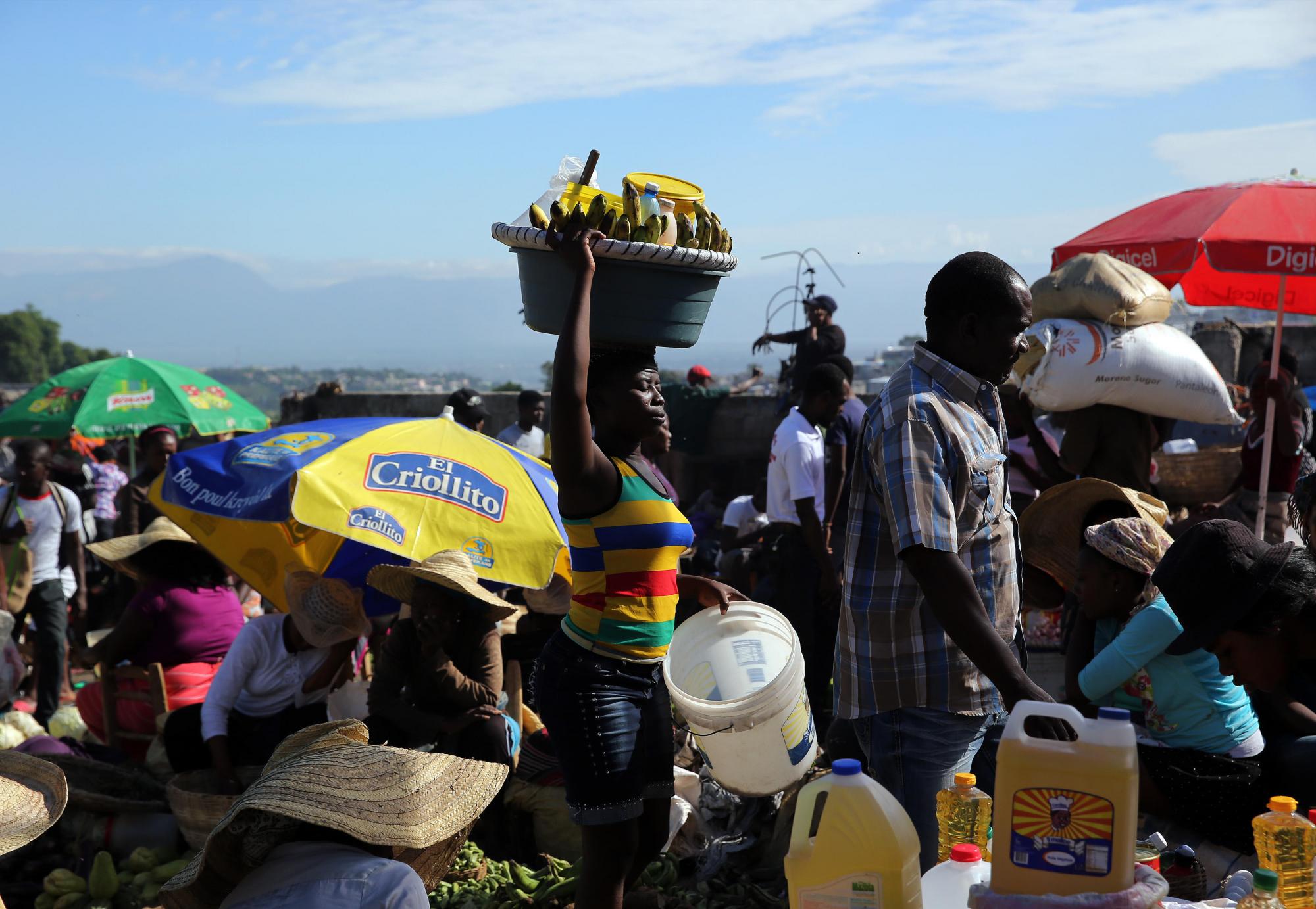 Varias personas caminan por un mercado en Puerto Príncipe.