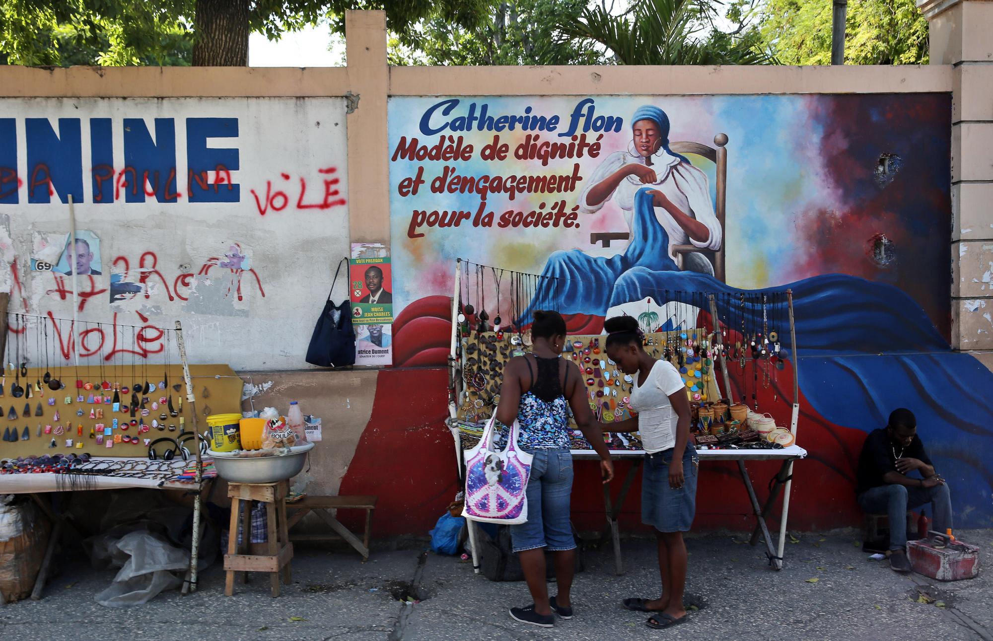 Dos chicas compran productos en un puesto callejero en Puerto Príncipe.