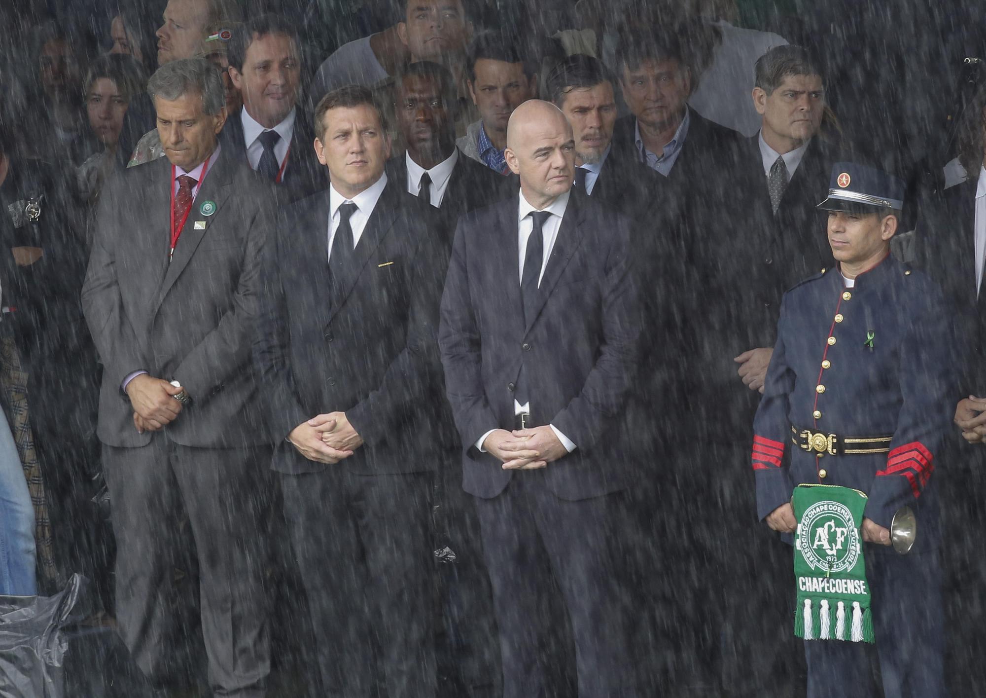 Los presidentes de la FIFA, Gianni Infantino, segundo de la derecha; de la Conmebol, Alejandro Domínguez, segundo izquierda, y el exfutbolista Clareence Seedorf (atrás), en el velorio de las víctimas, bajo lluvia, el pasado 3 de diciembre en el estadio Arena Condá.