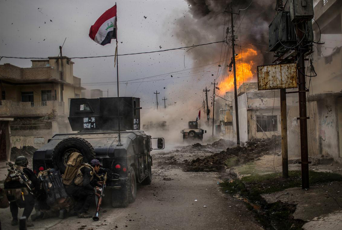 El 16 de noviembre un coche bomba explota junto a vehículos blindados de las fuerzas especiales iraquíes mientras avanzan hacia el territorio ocupado por el Estado islámico en Mosul, Irak. 