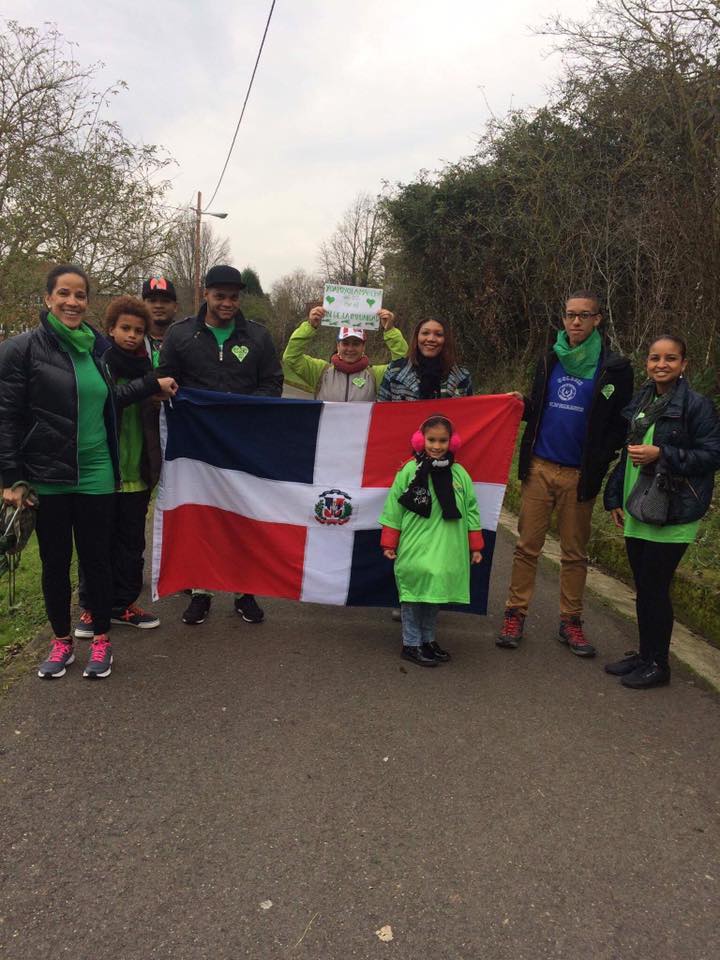 En Oviedo, España, una familia de origen dominicano sostiene una bandera y viste de verde, color elegido por los organizadores de la marcha “Fin de la impunidad” como sinónimo de esperanza.