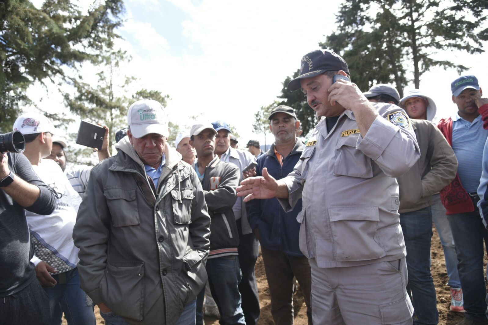 Un oficial de la Policía conversa con los agricultores en Valle Nuevo.