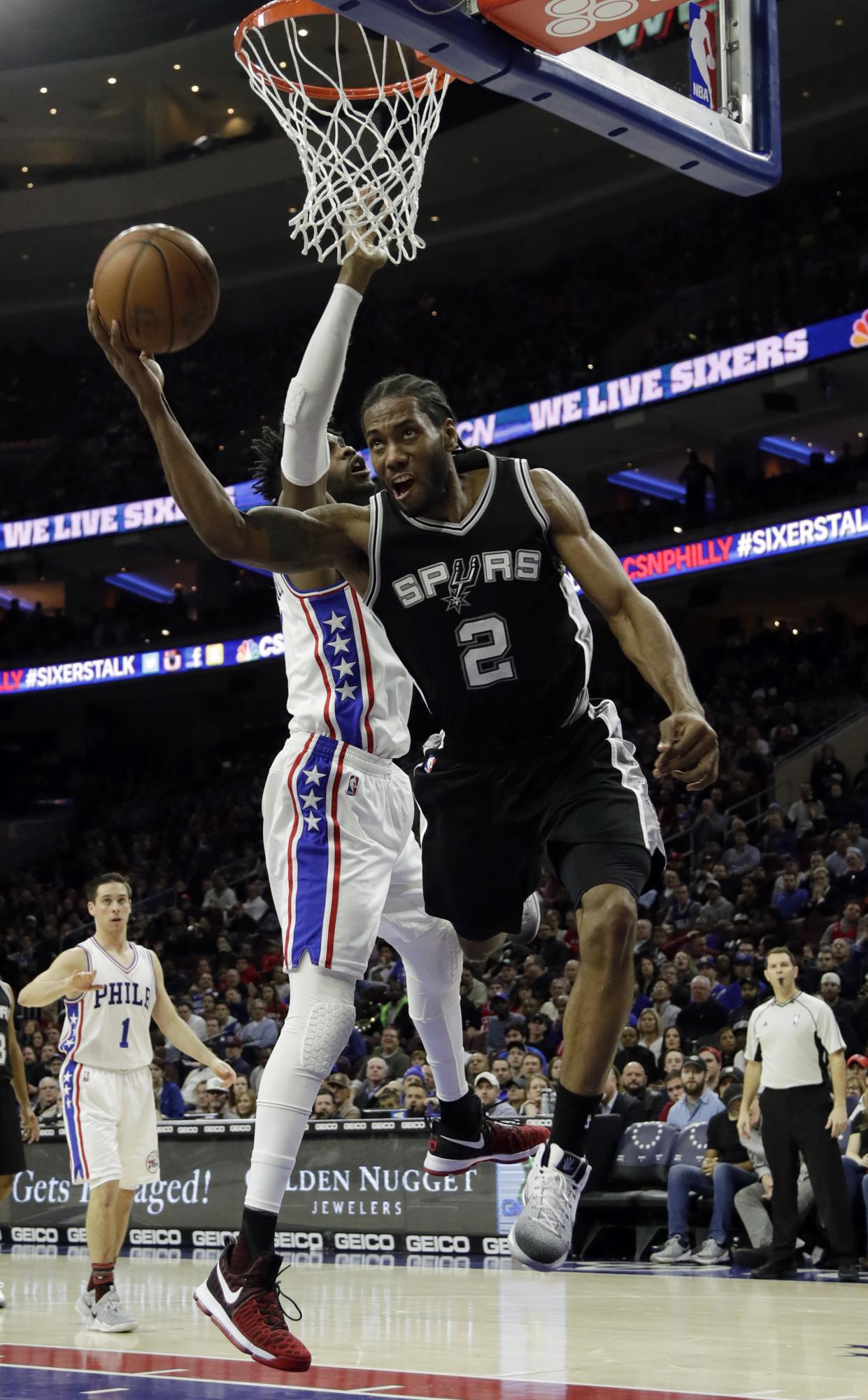 Kawhi Leonard, derecha, trata de conseguir un tiro, bloqueado por ‘Nerlens Noel.