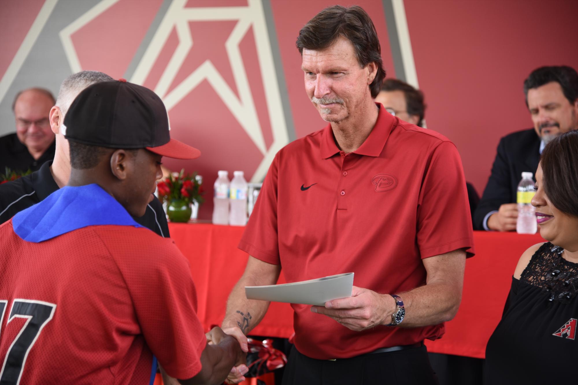 El miembro de Salón de la Fama de Cooperstown, Randy Johnson entrega uno de los diplomas en el acto de graduación de la Academias de las Diamantinas de Arizona.