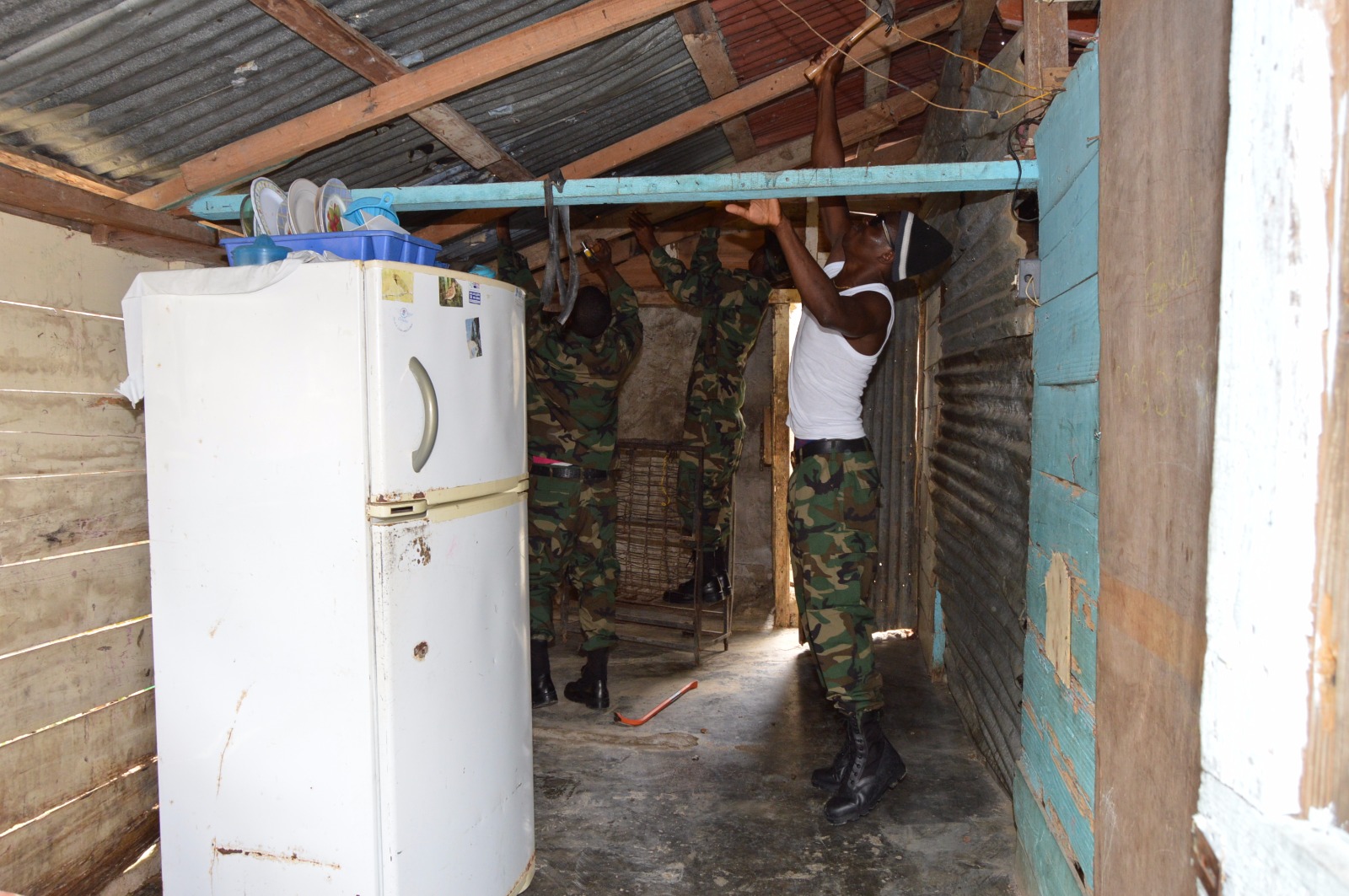 Militar repara techo de una casa. 