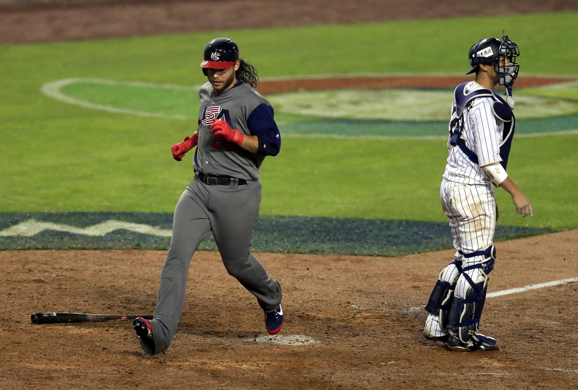 Brandon Crawford (i) llega al home la semifinal de la cuarta edición del Clásico Mundial de Béisbol entre EE.UU. y Japón celebrada en Los Ángeles, California, Estados Unidos, el 21 de marzo de 2017.