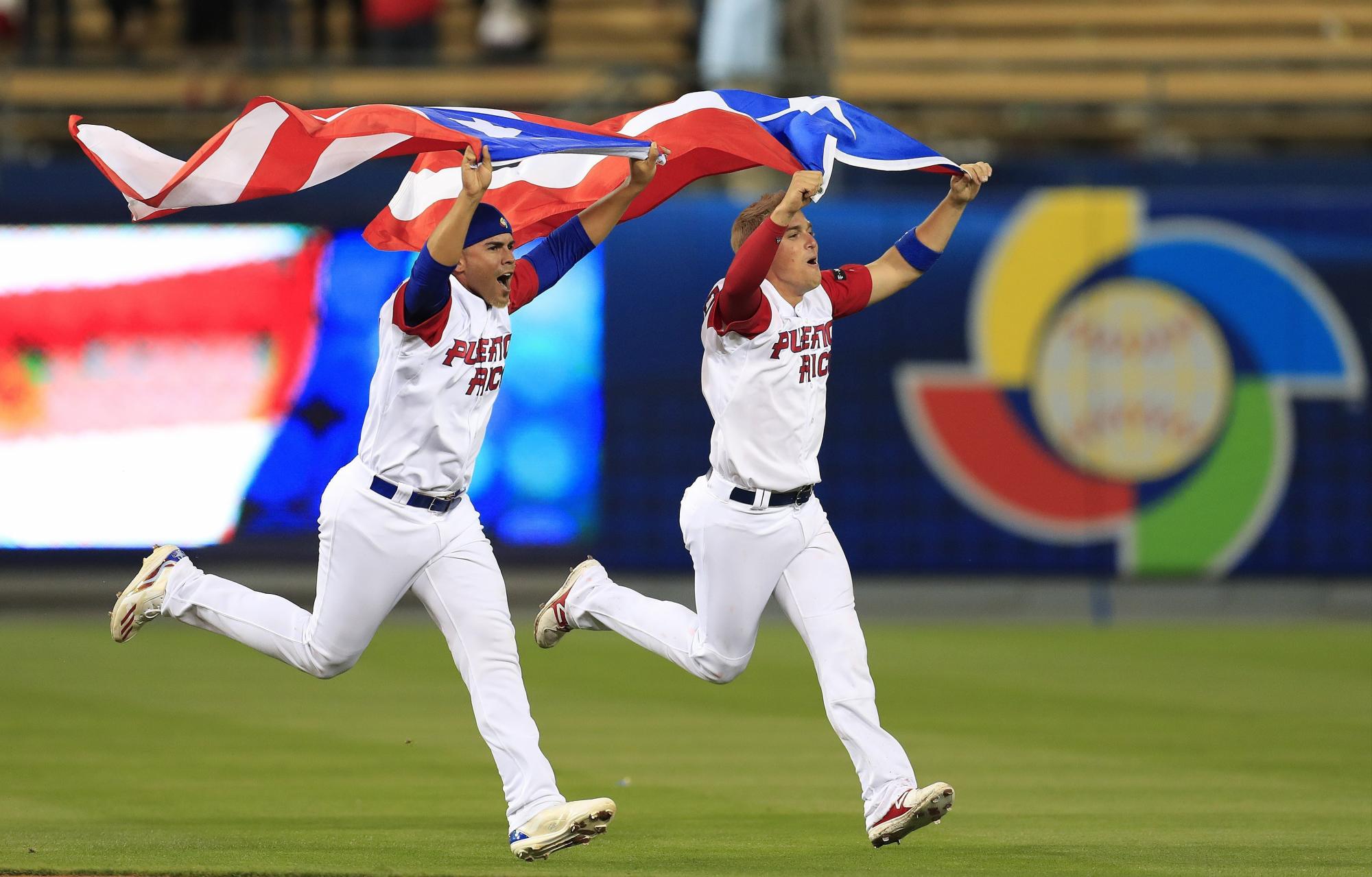 El lanzador de Puerto Rico Hiram Burgos (i) celebra la victoria de su equipo con su compañero Kike Hernández (d) anoche tras la primera semifinal del Clásico Mundial de Béisbol entre Puerto Rico y Holanda celebrado en Los Ángeles.