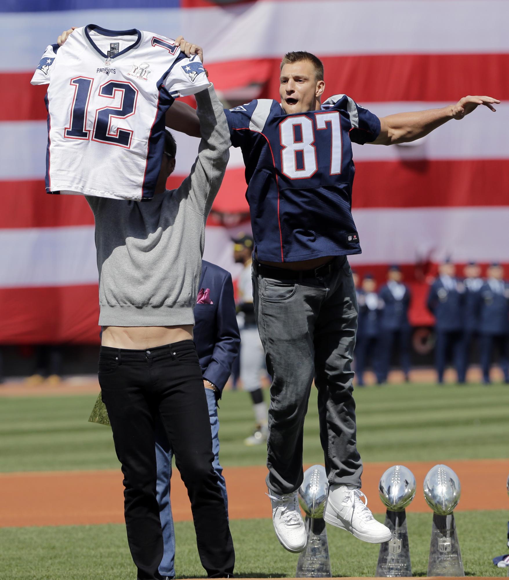 Rob Gronkowski, de los Patriots, salta sobre su compañero de equipo Tom Brady para bromear quitándole la camiseta que le había sido robada al “quaterback” de New England durante el Super Bowl. La broma ocurrió el 3 de abril en la apertura del equipo de Boston.