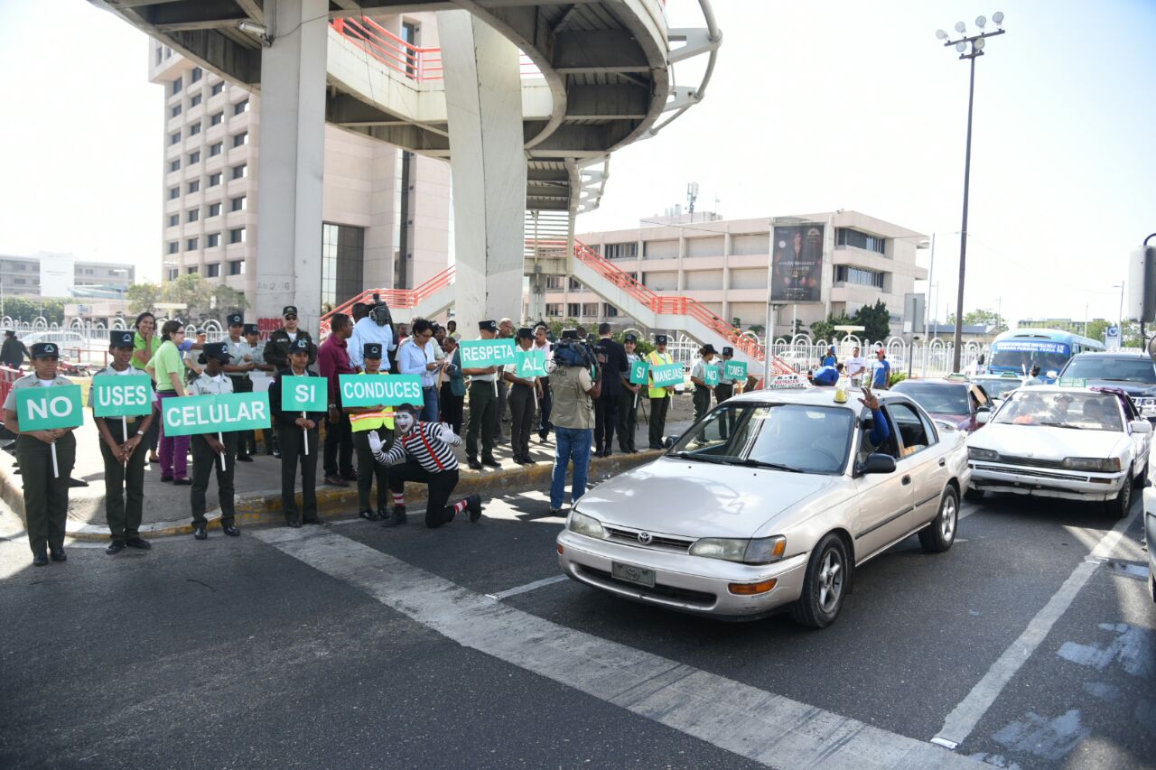  Agentes de la AMET,  en la esquina de las avenidas John F. Kennedy con Máximo Gómez,  con mensajes a los conductores que los motivan a respetar las leyes.