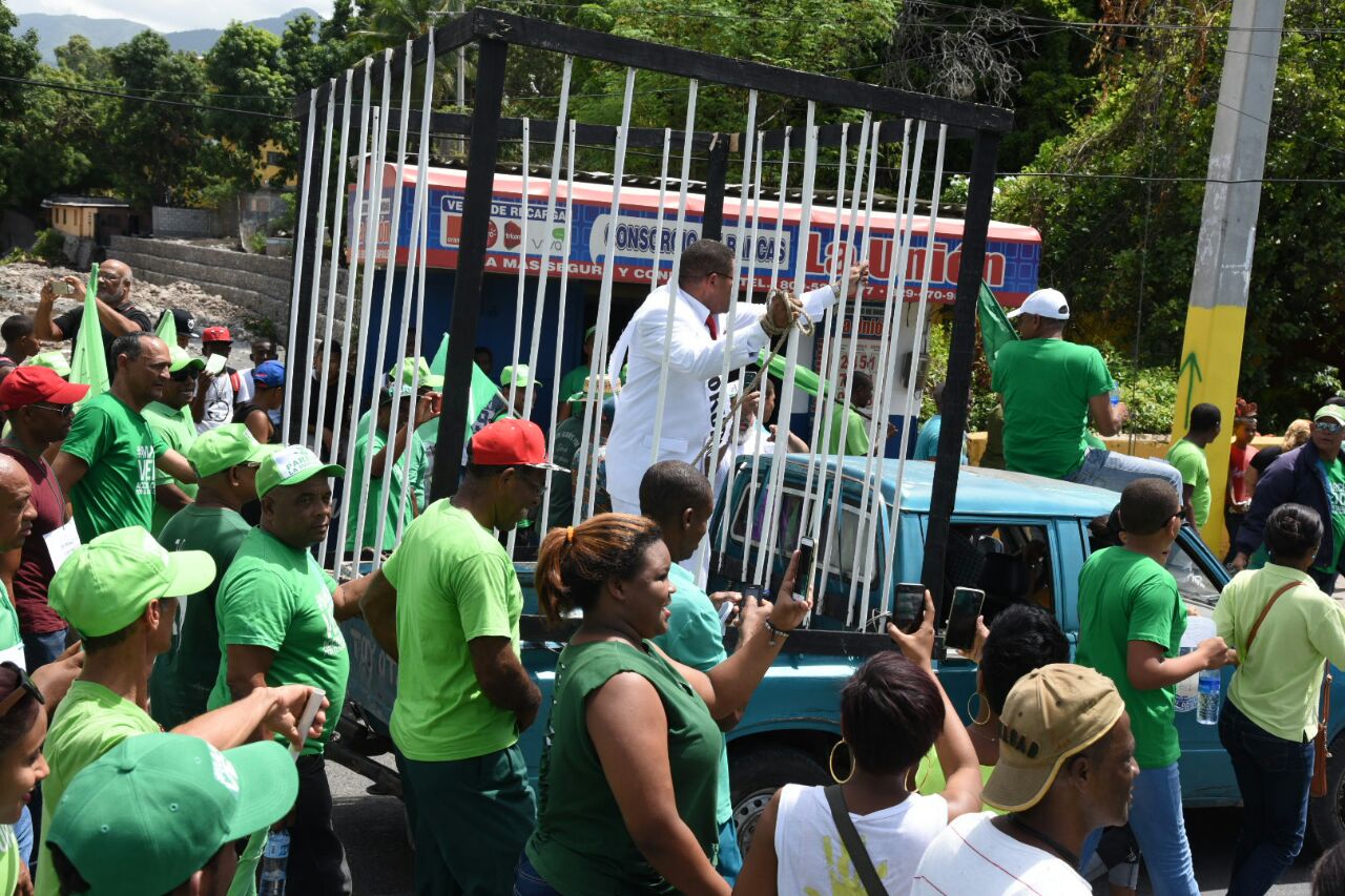 Un hombre con una banda que dice Corrupto y “encarcelado” se exhibe como alegoría para demandar el fin de la impunidad.