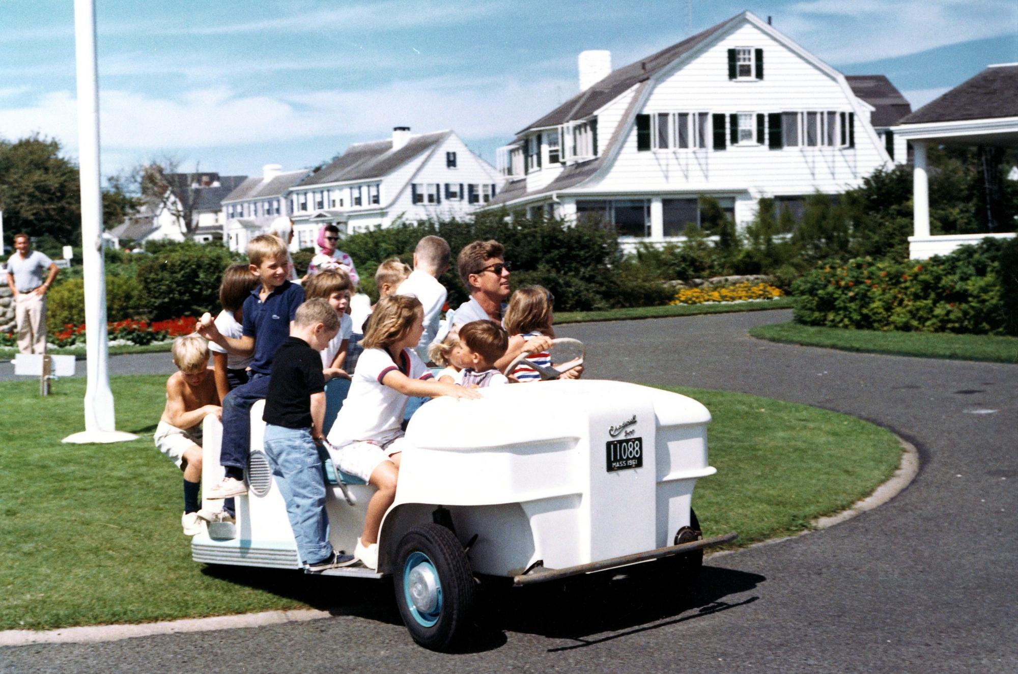 John F. Kennedy (2d), junto a sus sobrinos en un carro de golf en su casa de verano en Hyannisport.