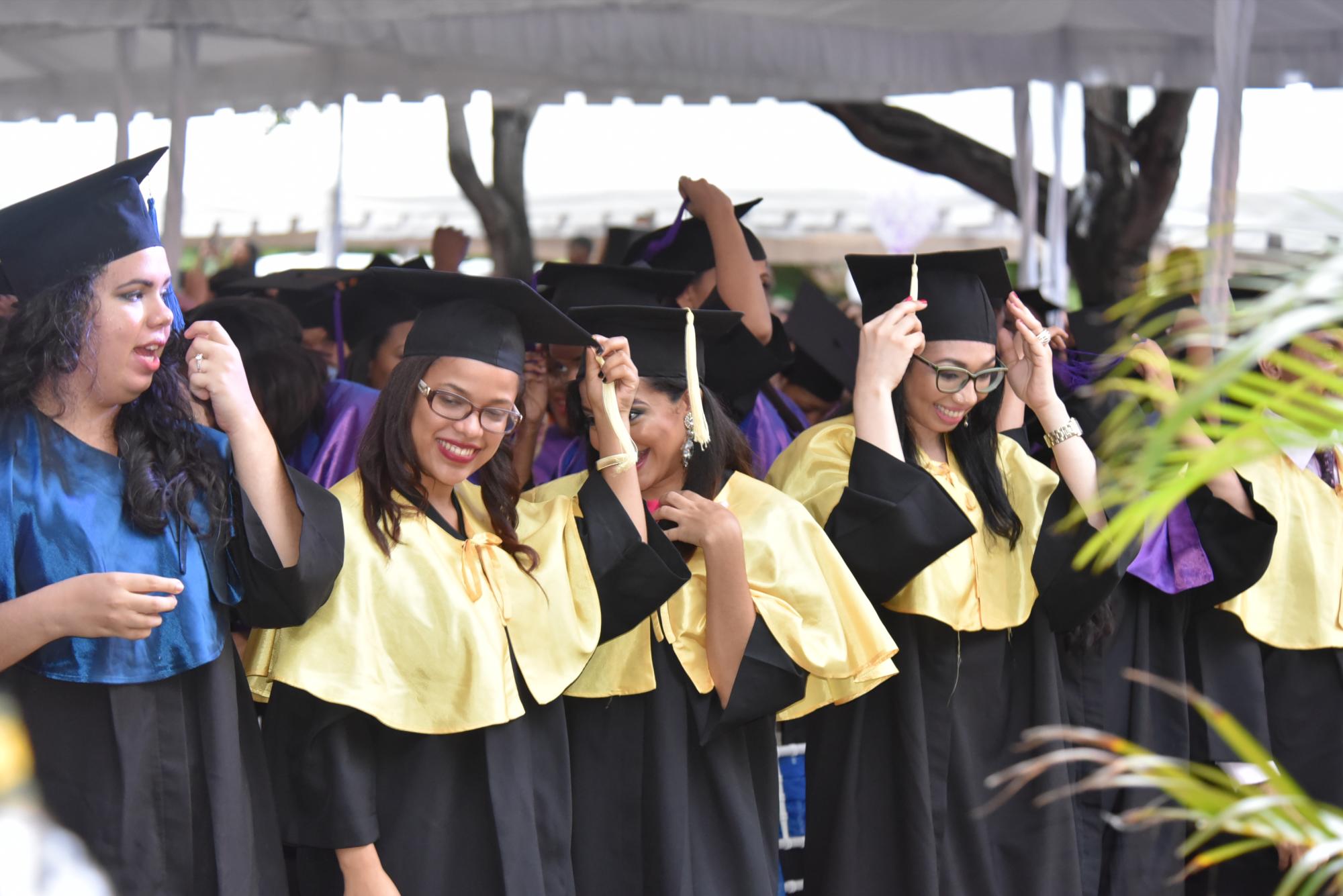 Graduandos se disponen a tirar hacia arriba sus birretes.