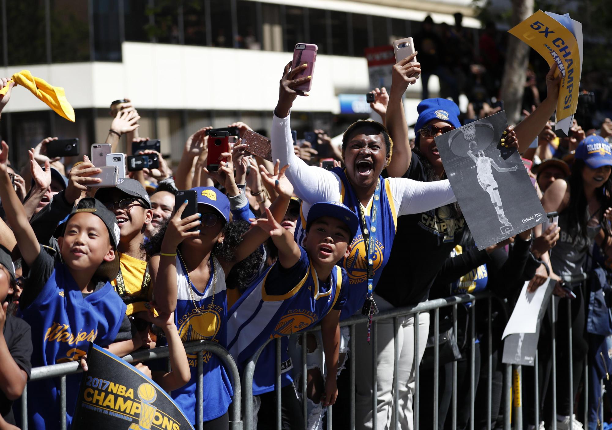 Fanáticos de Golden State Warriors celebran durante el Desfile.
