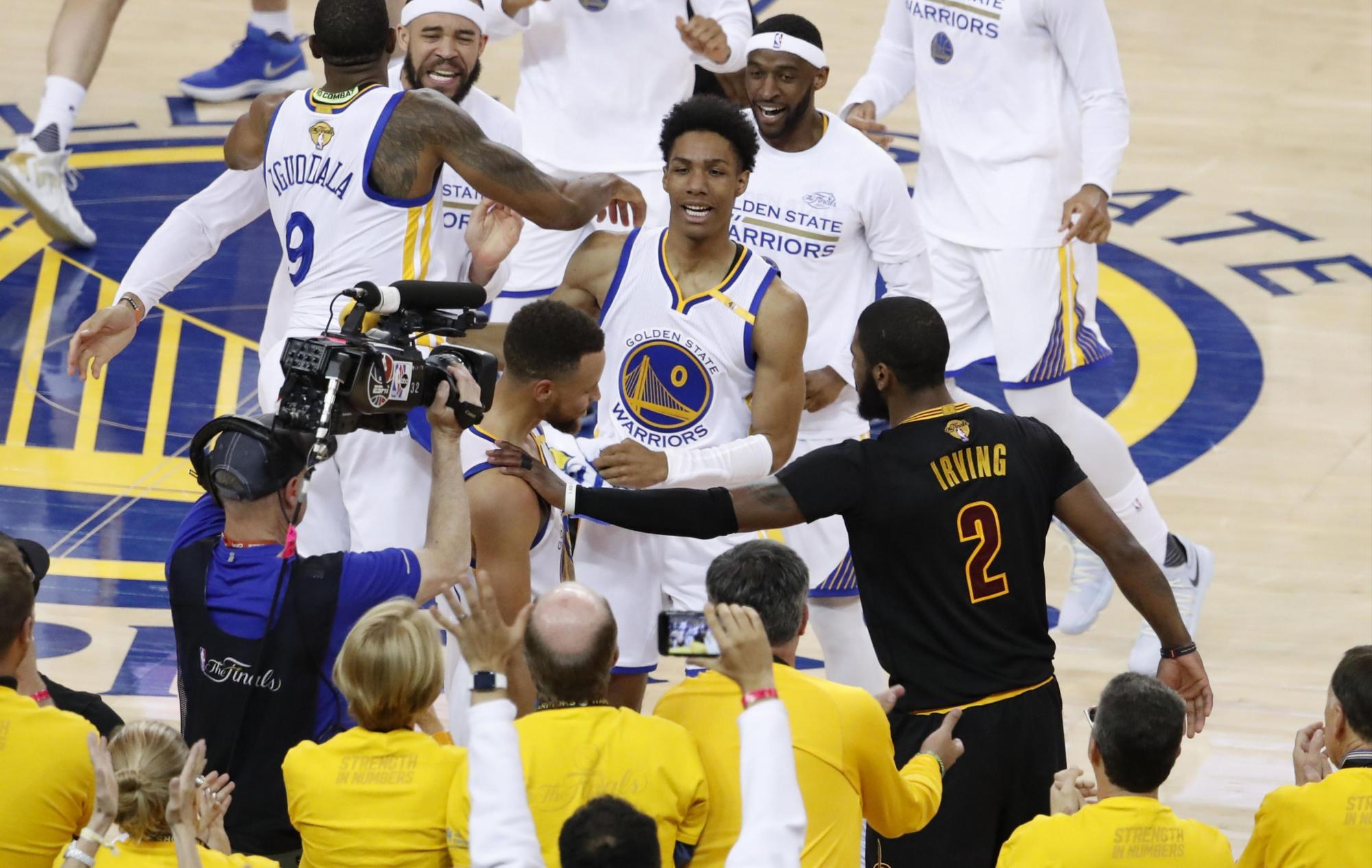 Stephen Curry (c), de los Warriors de Golden State, es felicitado por Kyrie Irving (dcha), de los Cavaliers de Cleveland.