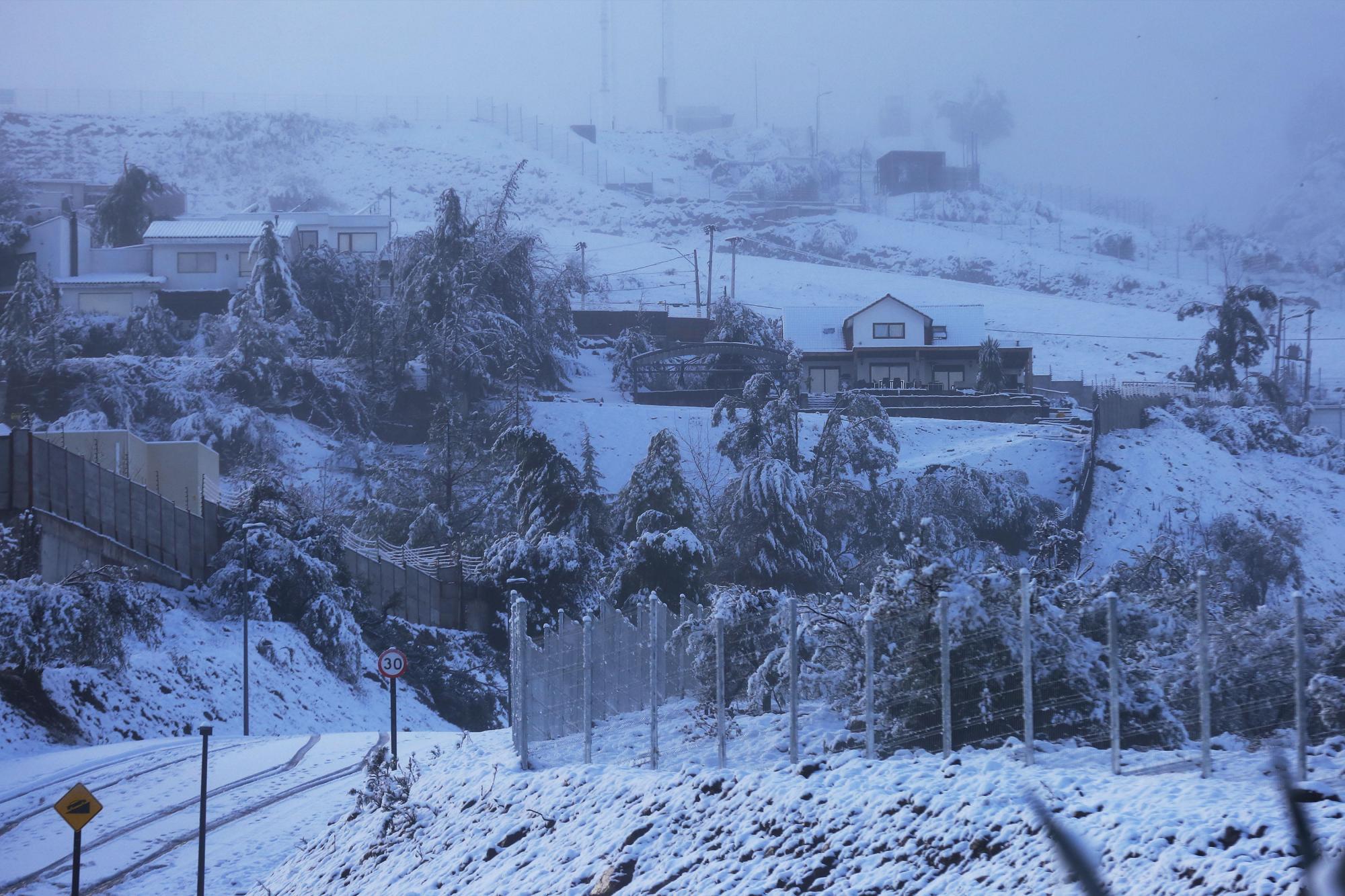 Vista general de un conjunto de casa cubiertas por nieve hoy, sábado 15 de julio de 2017, en Santiago (Chile).