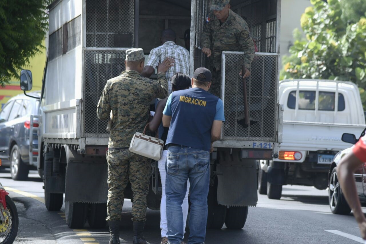 Un hombre y una mujer son detenidos este lunes por miembros de la Dirección General de Migración, en Santiago.