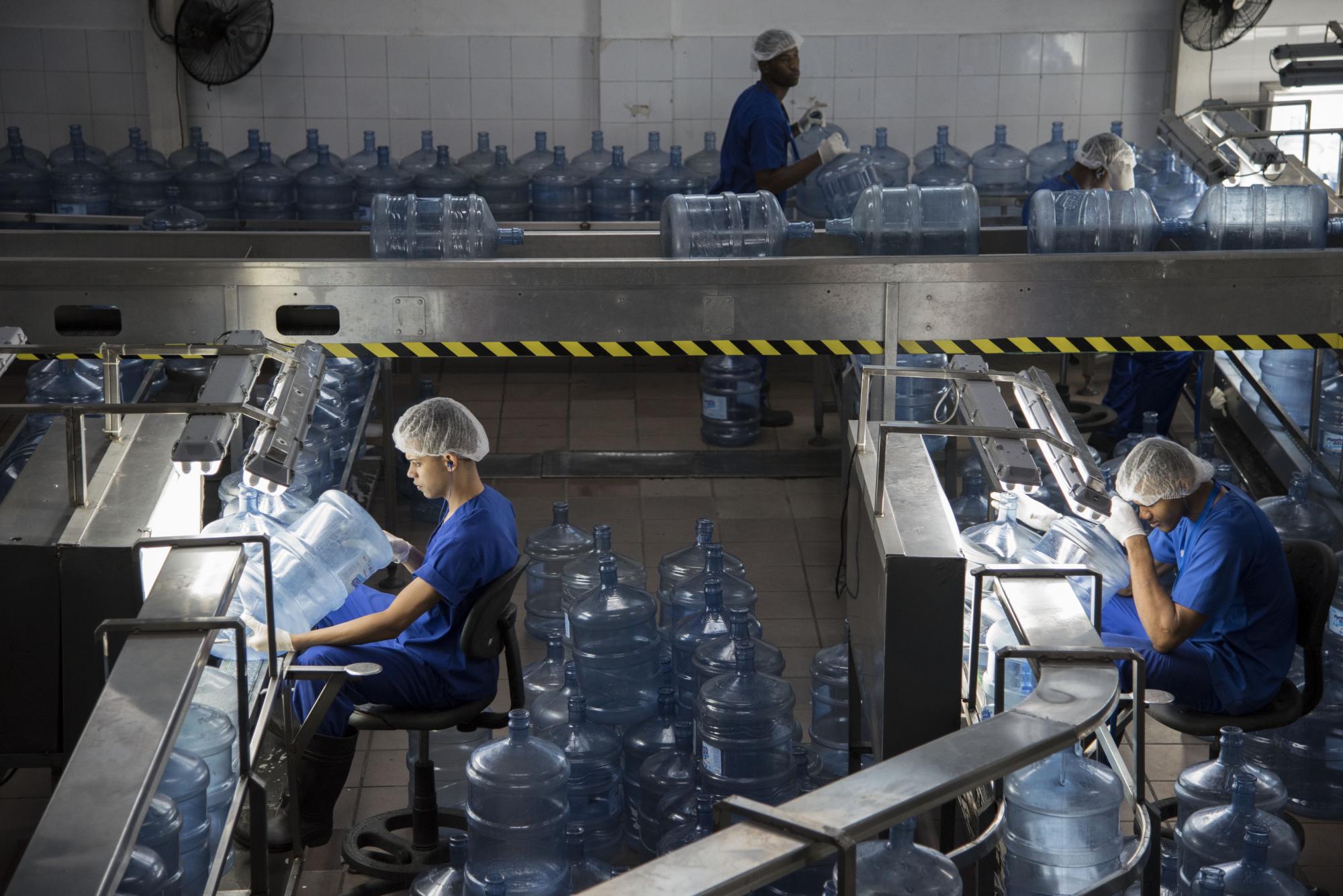 Los operadores verifican que los galones no tengan impurezas.