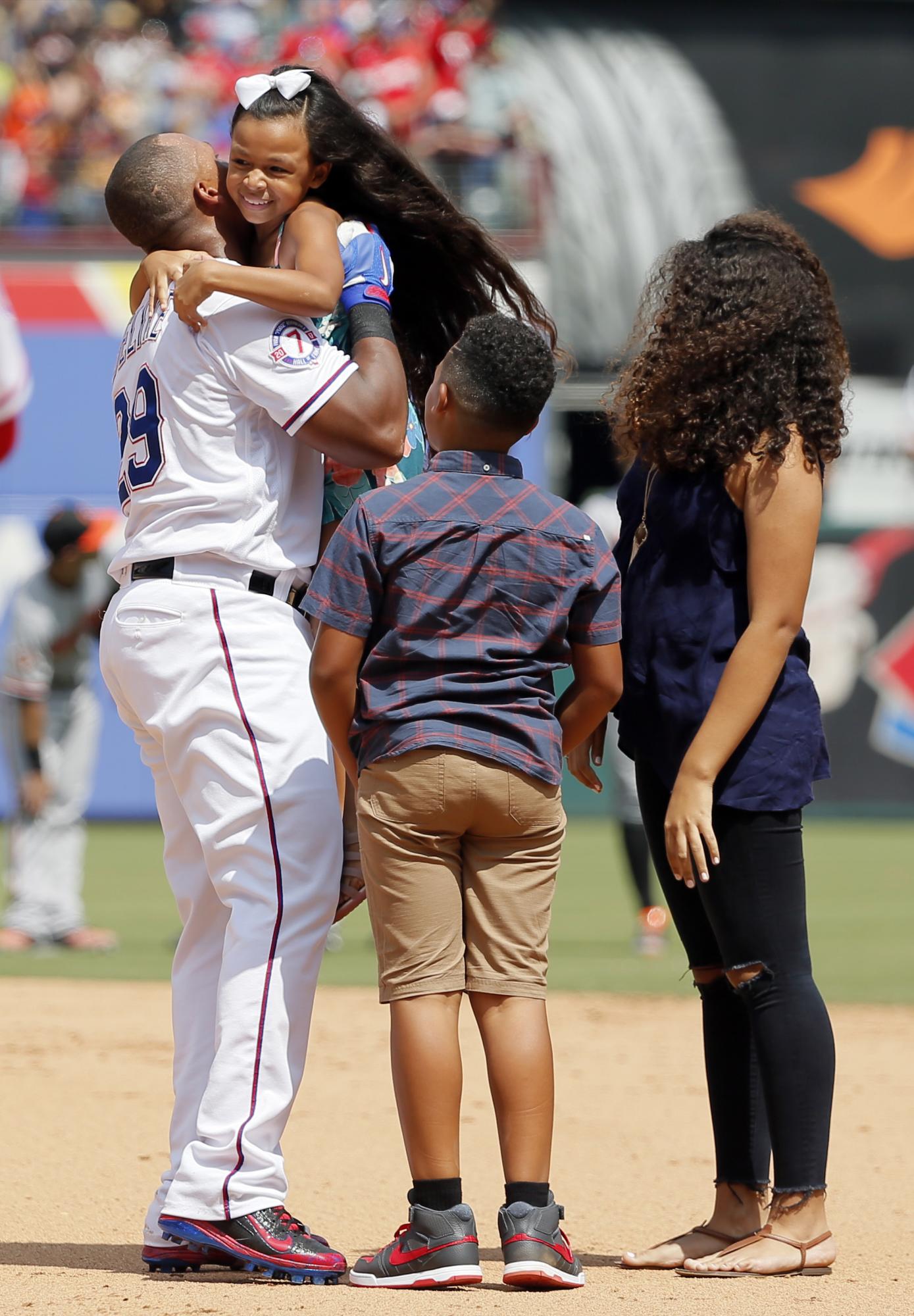 Adrian Beltré es felicitado por sus hijos Canila, a quien carga; Adrian Jr.(centro) y Cassandra (derecha) en el field después que el pelotero diera su hits 3,000 en el partido  en que los Vigilantes de Texas enfrentaron a los Orioles de Baltimore este domingo 30 de julio de 2017, en Arlington, Texas. 