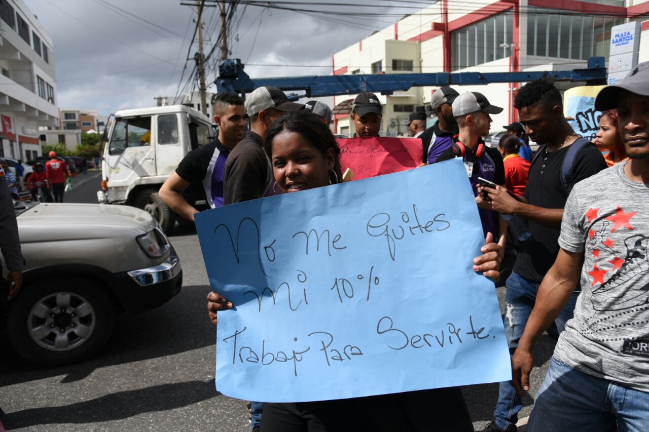 Empleada muestra cartel de protesta.