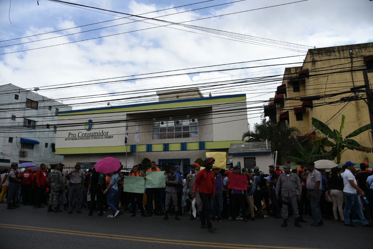 Manifestantes custodiados por policías frente a Pro Consumidor.