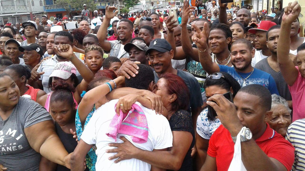 Familiares abrazan a los pescadores liberados. 