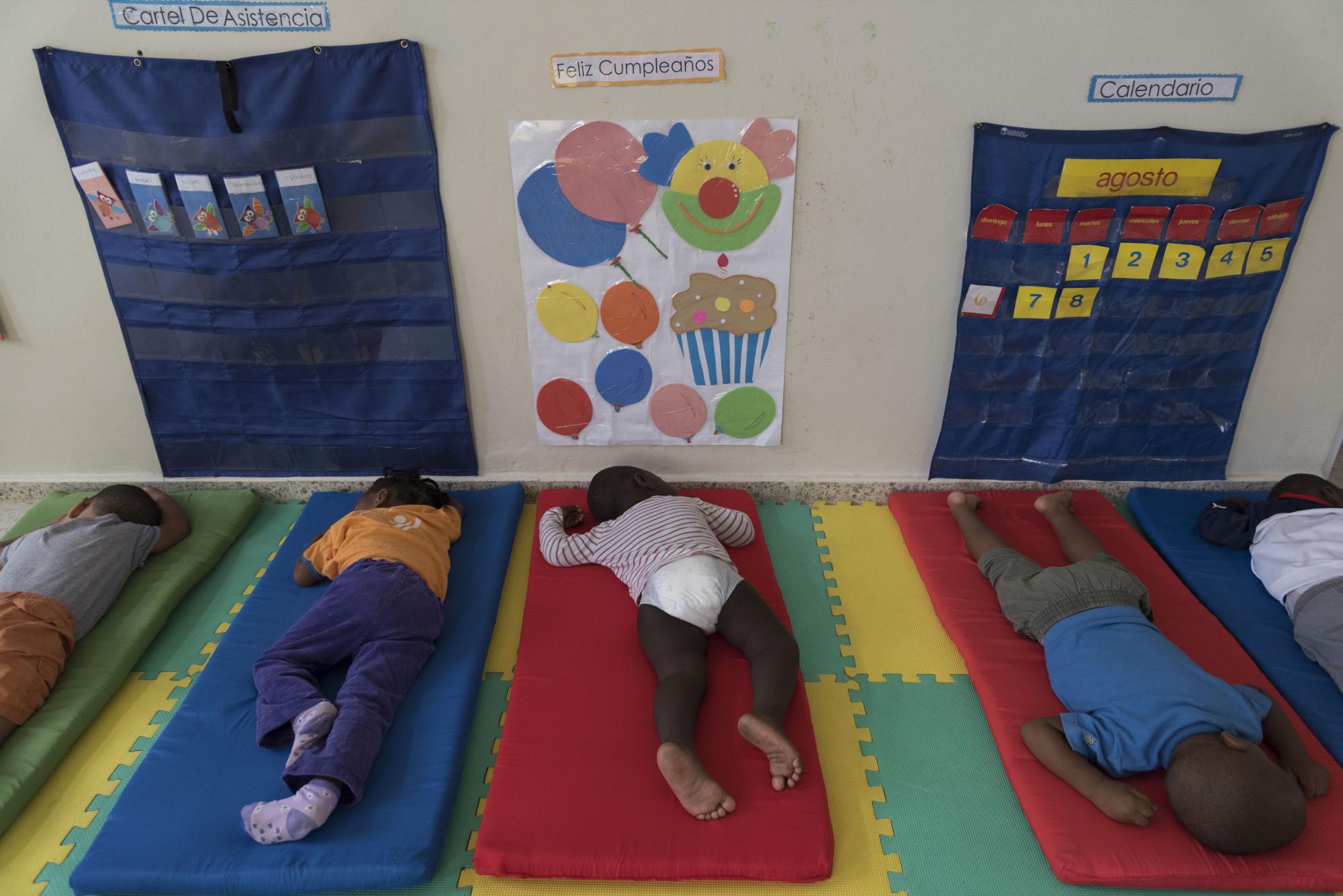 Niños de las salas de dos a tres años duermen depués de almorzar en el CAIPI Brisas del Norte, Boca Chica, donde son acogidos diariamente por espacio de nueve horas y media de lunes a viernes.