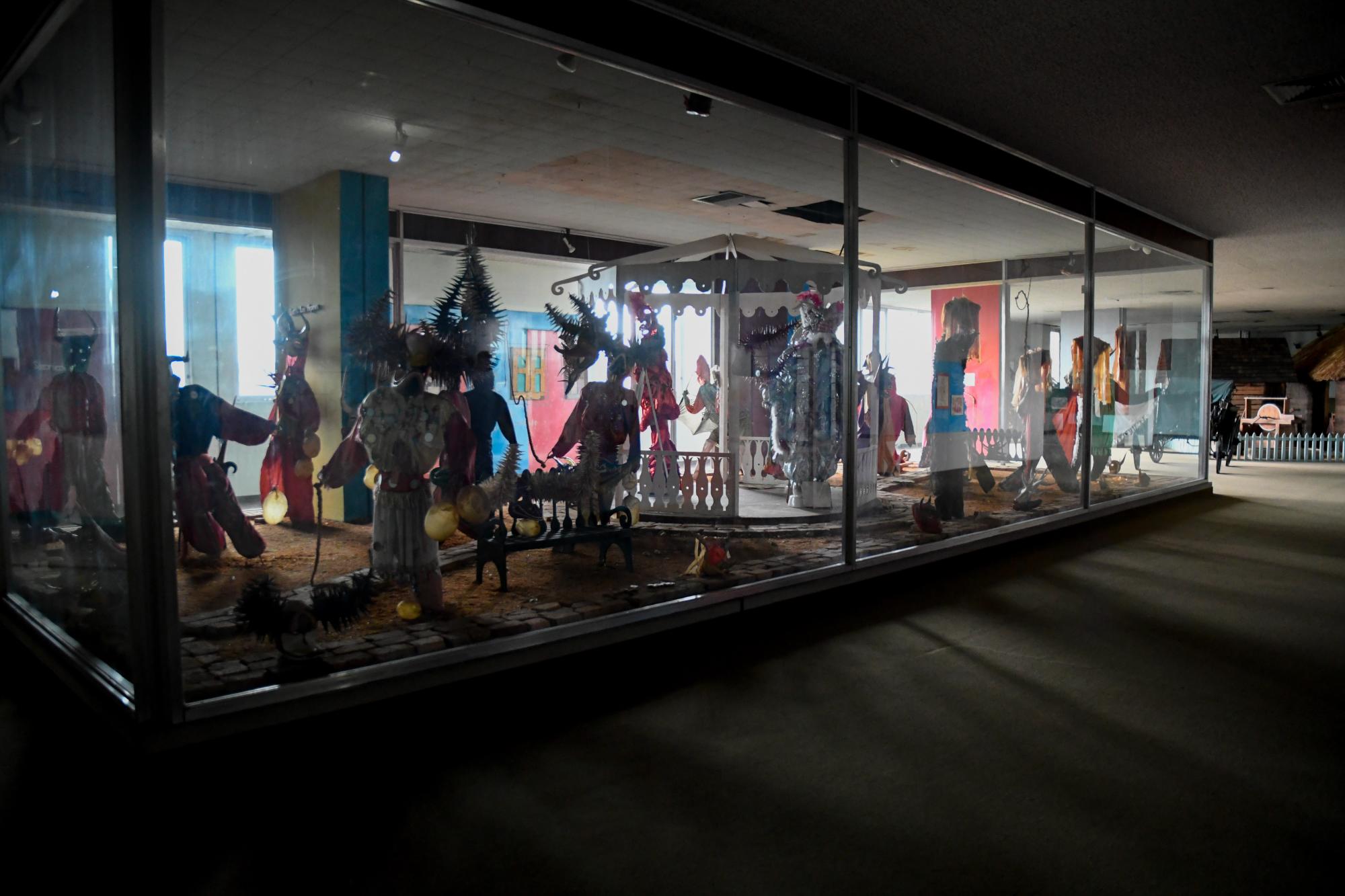 Exposición de personajes del carnaval dominicano en una sala a la que le falta mantenimiento.