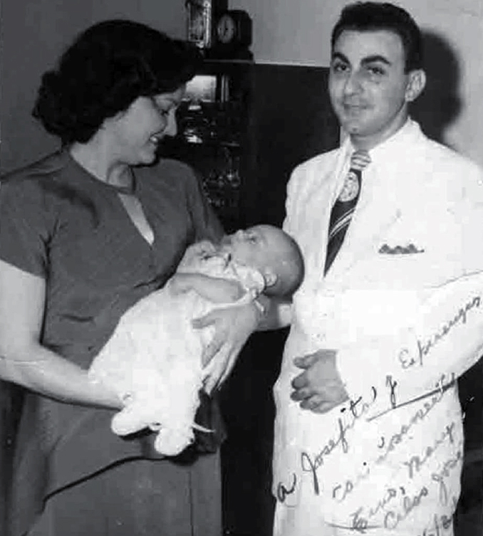 Doña Mary sostiene en sus brazos a su primogénito el día del bautizo. A su lado, su esposo Constantino Marranzini.