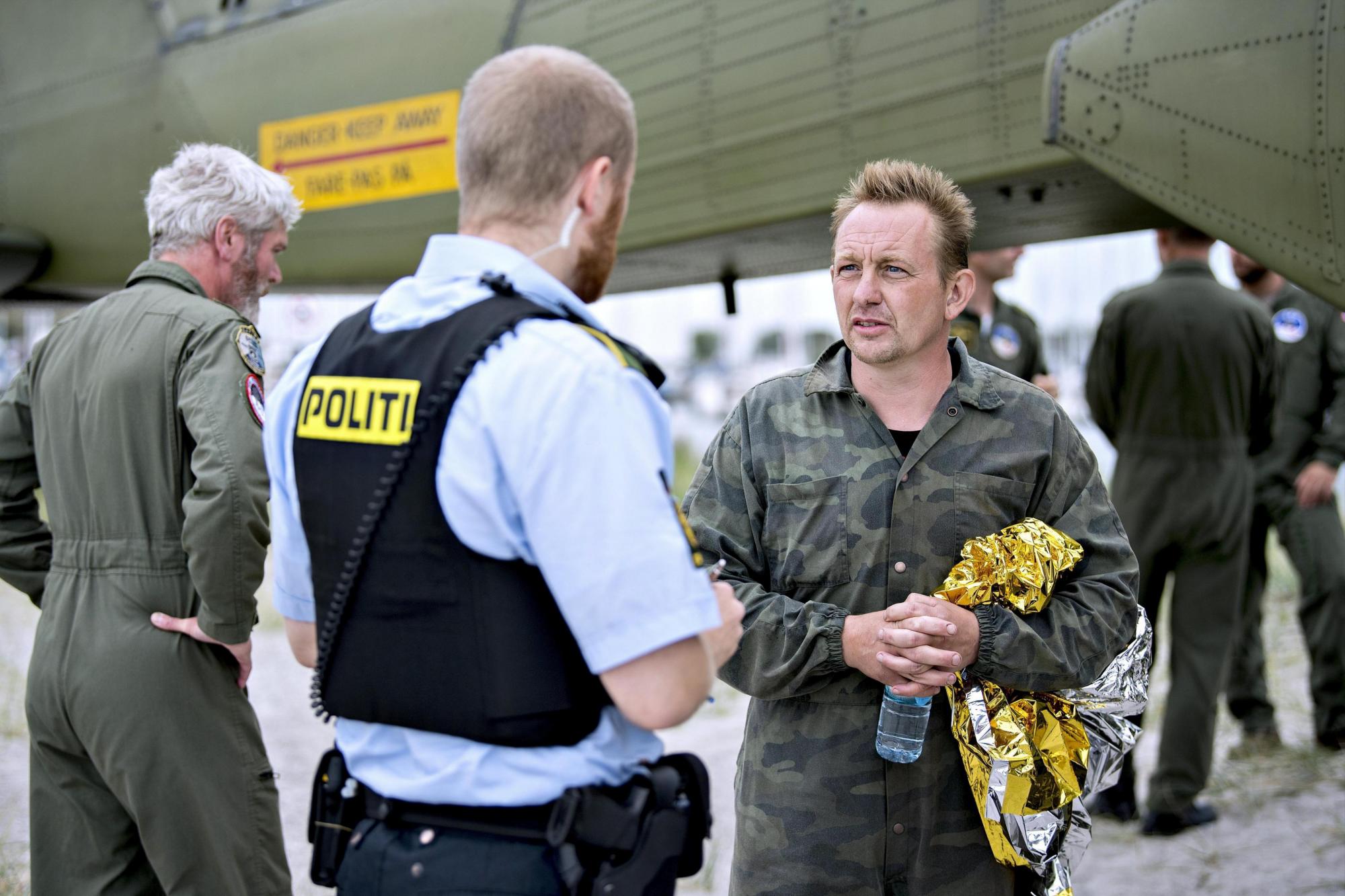 El propietario del submarino danés e inventor, Peter Madsen (d), habla con la policía danesa tras su emersión con la ayuda de las Fuerzas Armadas en el puerto Dragor, Copenhague (Dinamarca) hoy, 11 de agosto de 2017