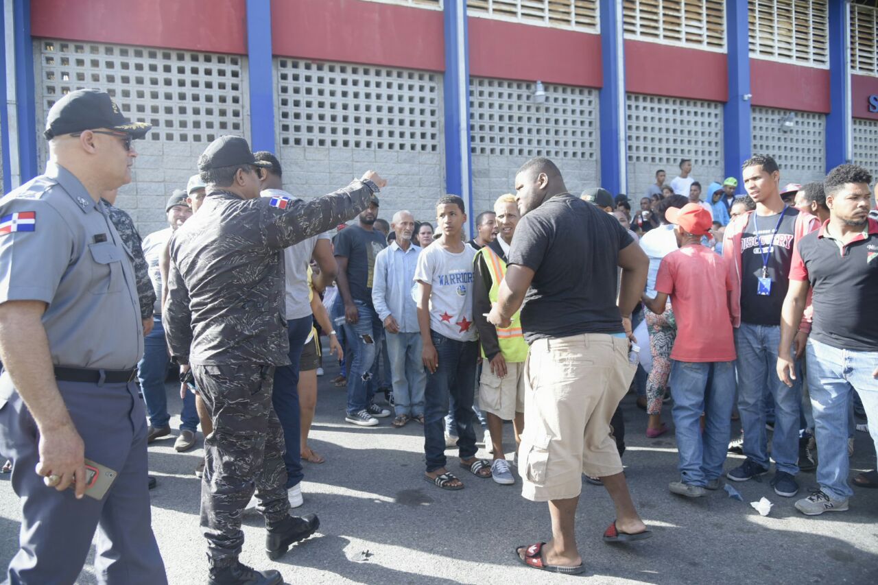 Agentes policiales tratan de calmar a la multitud enardecida por la presencia de Marlyn Martínez.