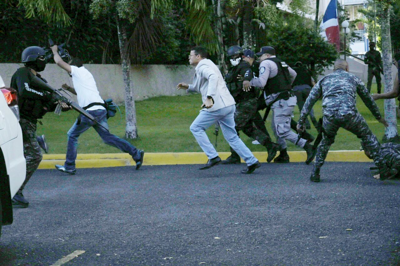 Agentes policiales corren ante la avalancha de piedras.