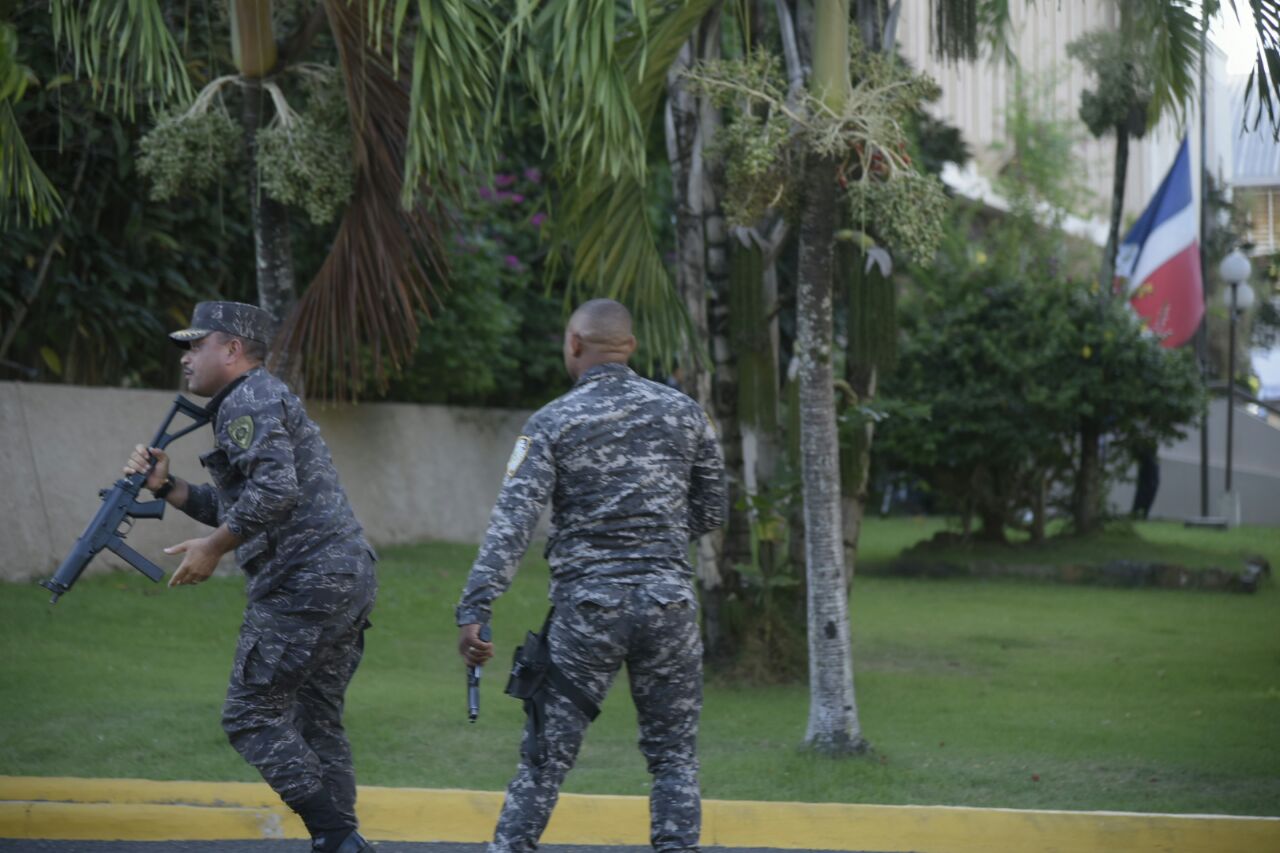 Agentes policiales corren ante la avalancha de piedras.